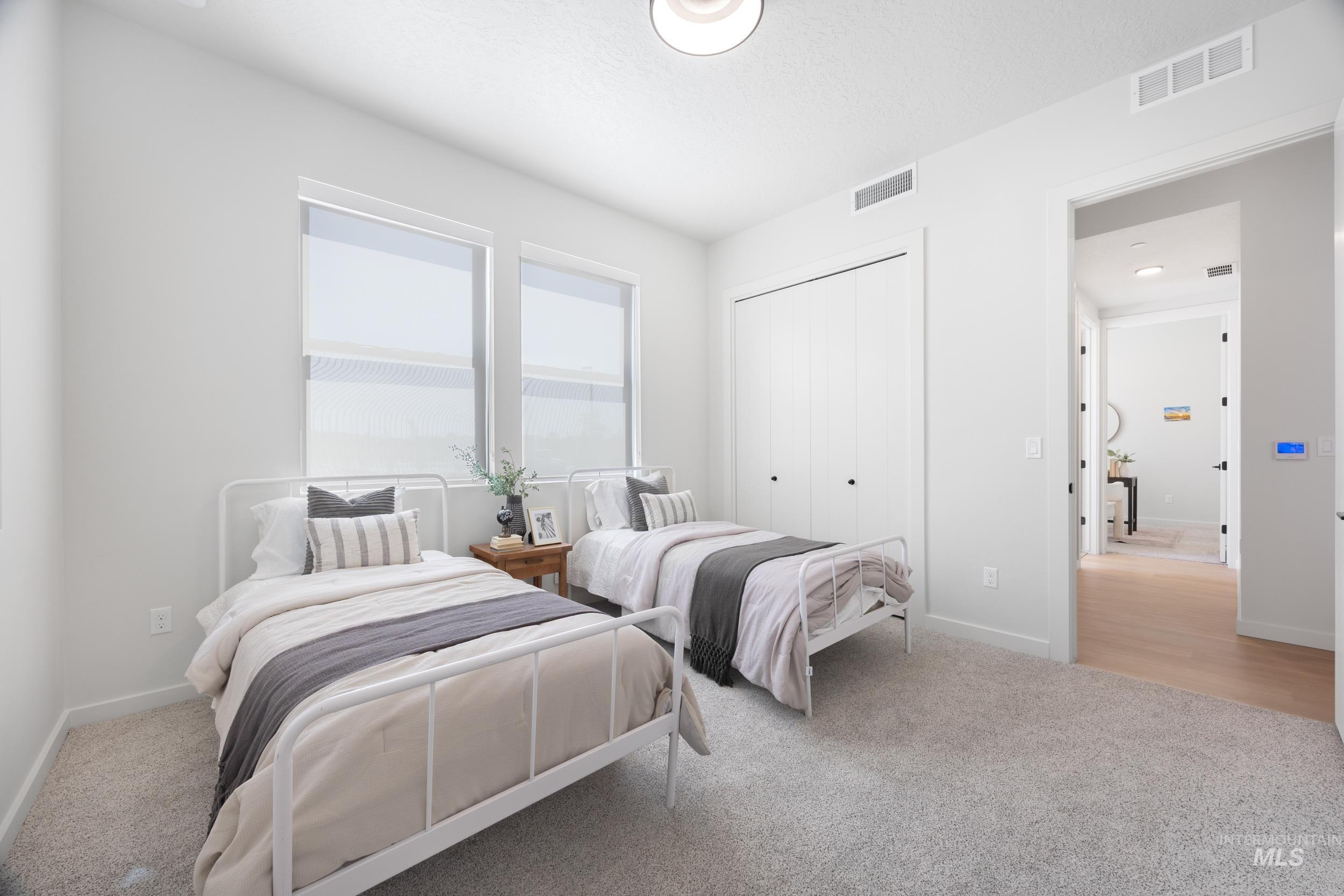Bedroom with light colored carpet and a closet