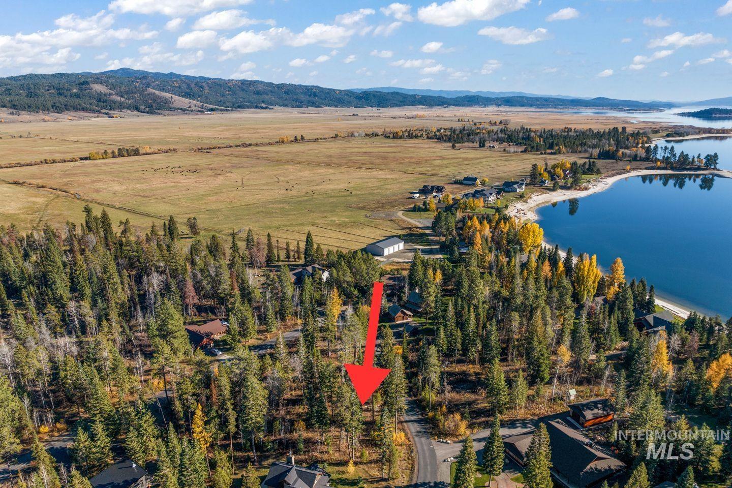 Aerial view of property and surrounding area featuring a water and mountain view