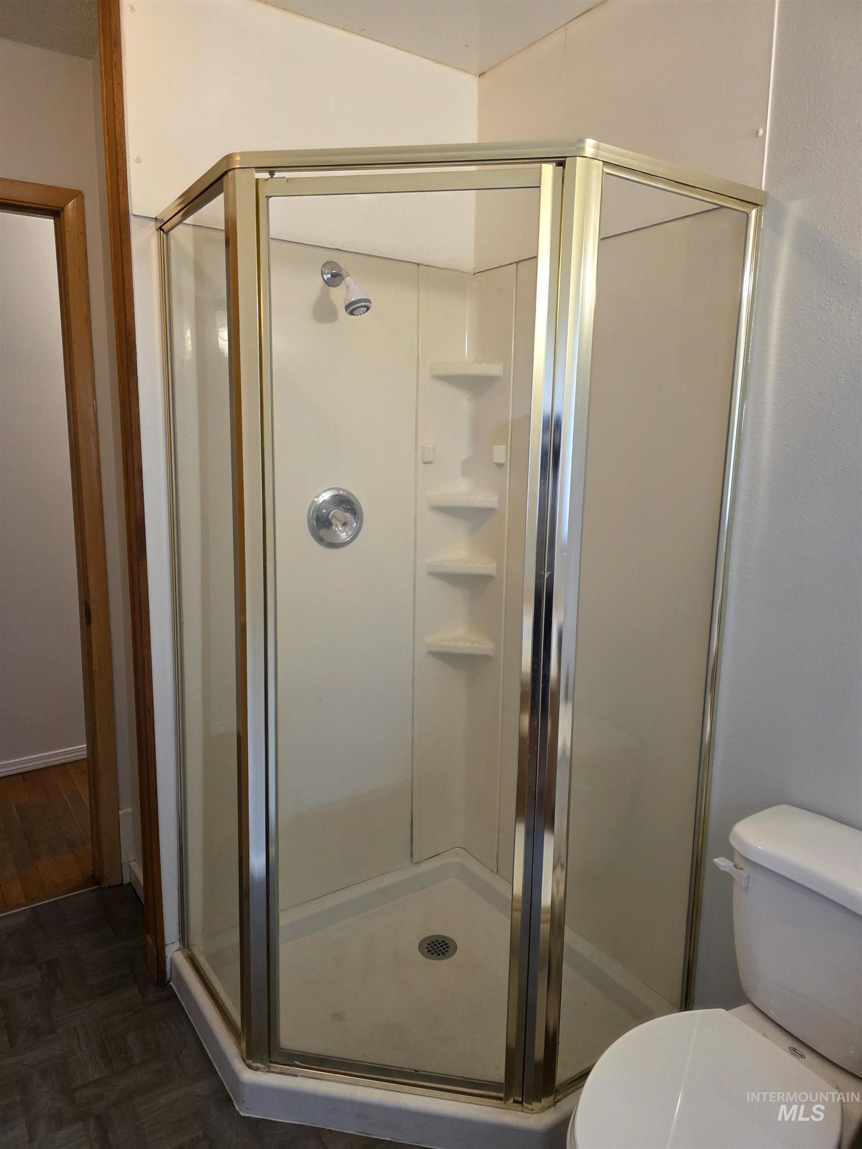 Bathroom with a shower stall and toilet