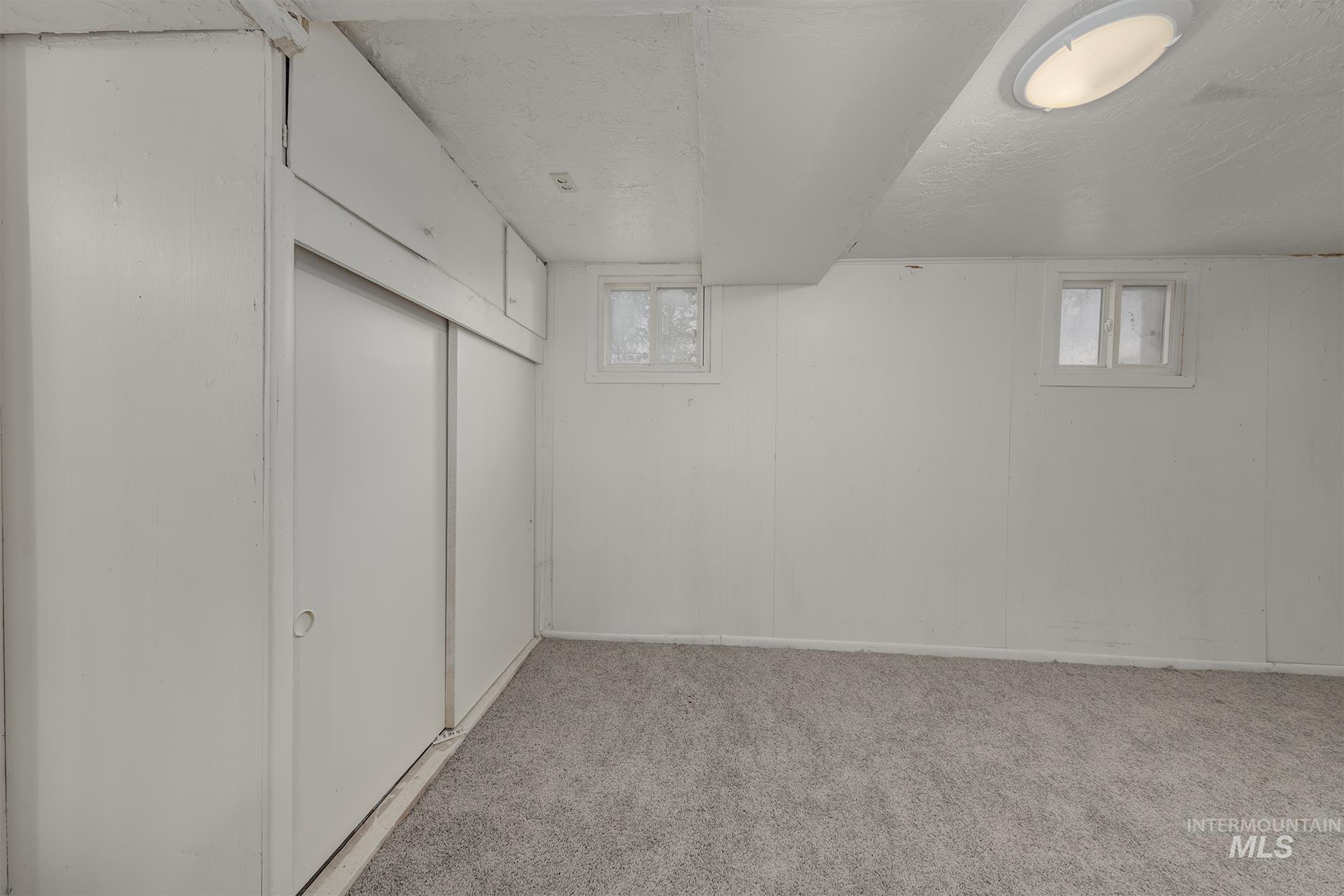 Below grade area with light carpet and baseboards