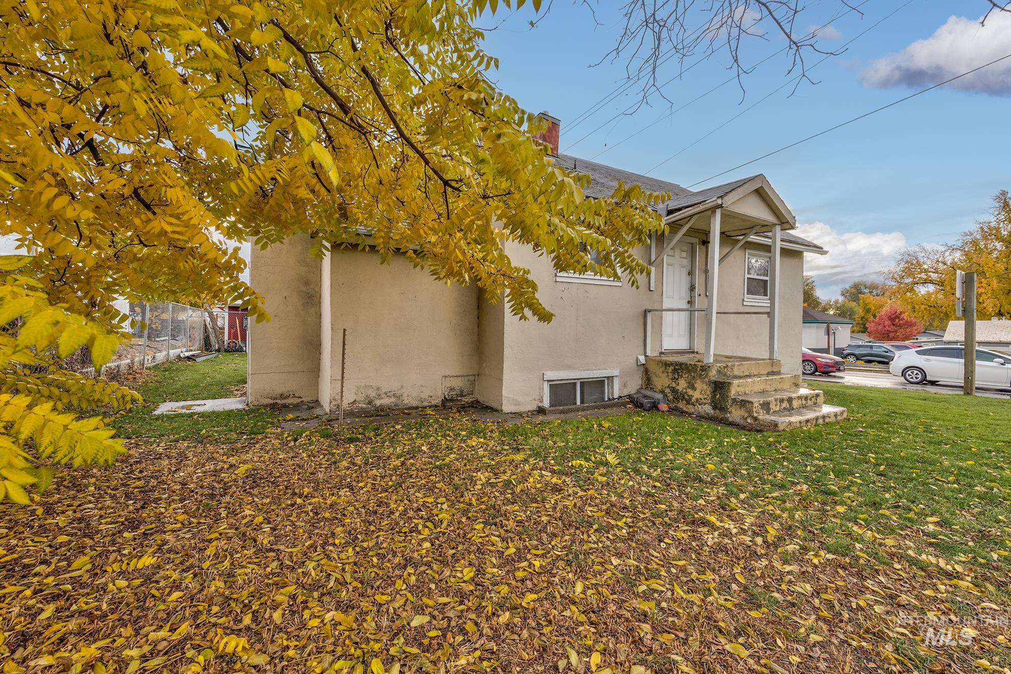 View of side of home featuring stucco siding, a lawn, and a chimney