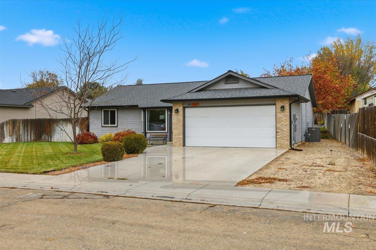 Ranch-style house with brick siding, concrete driveway, roof with shingles, and an attached garage