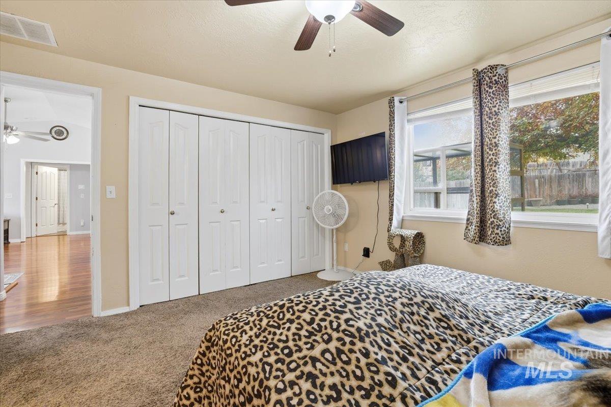Carpeted bedroom with a closet and a ceiling fan