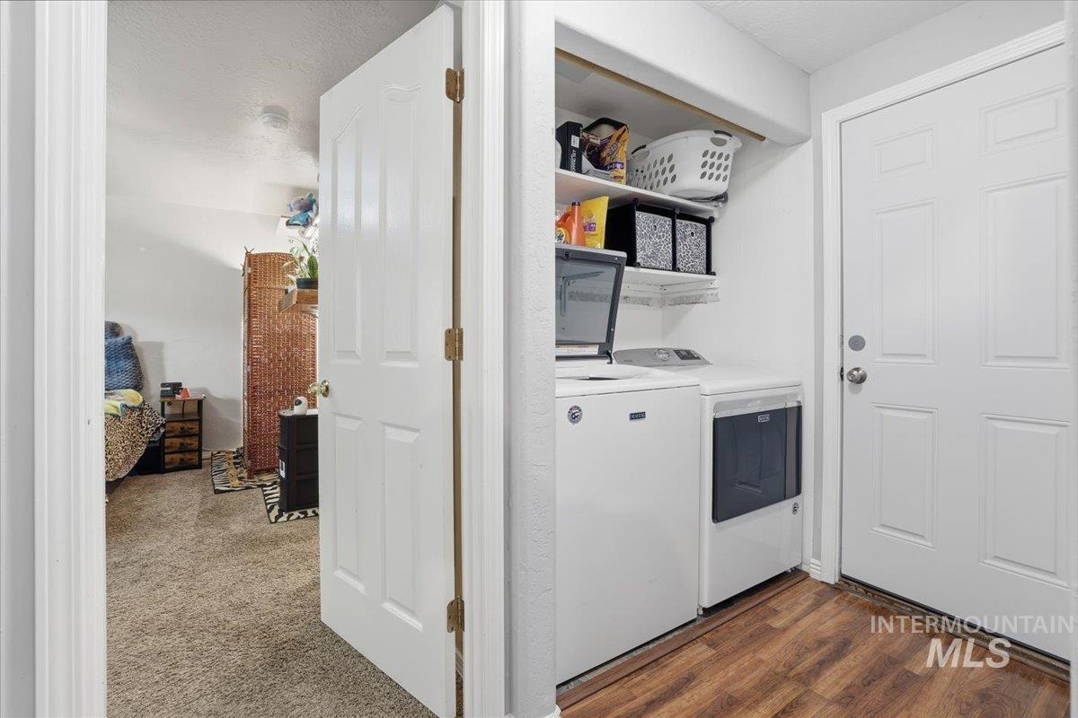 Laundry room featuring washer and dryer and dark wood-style floors
