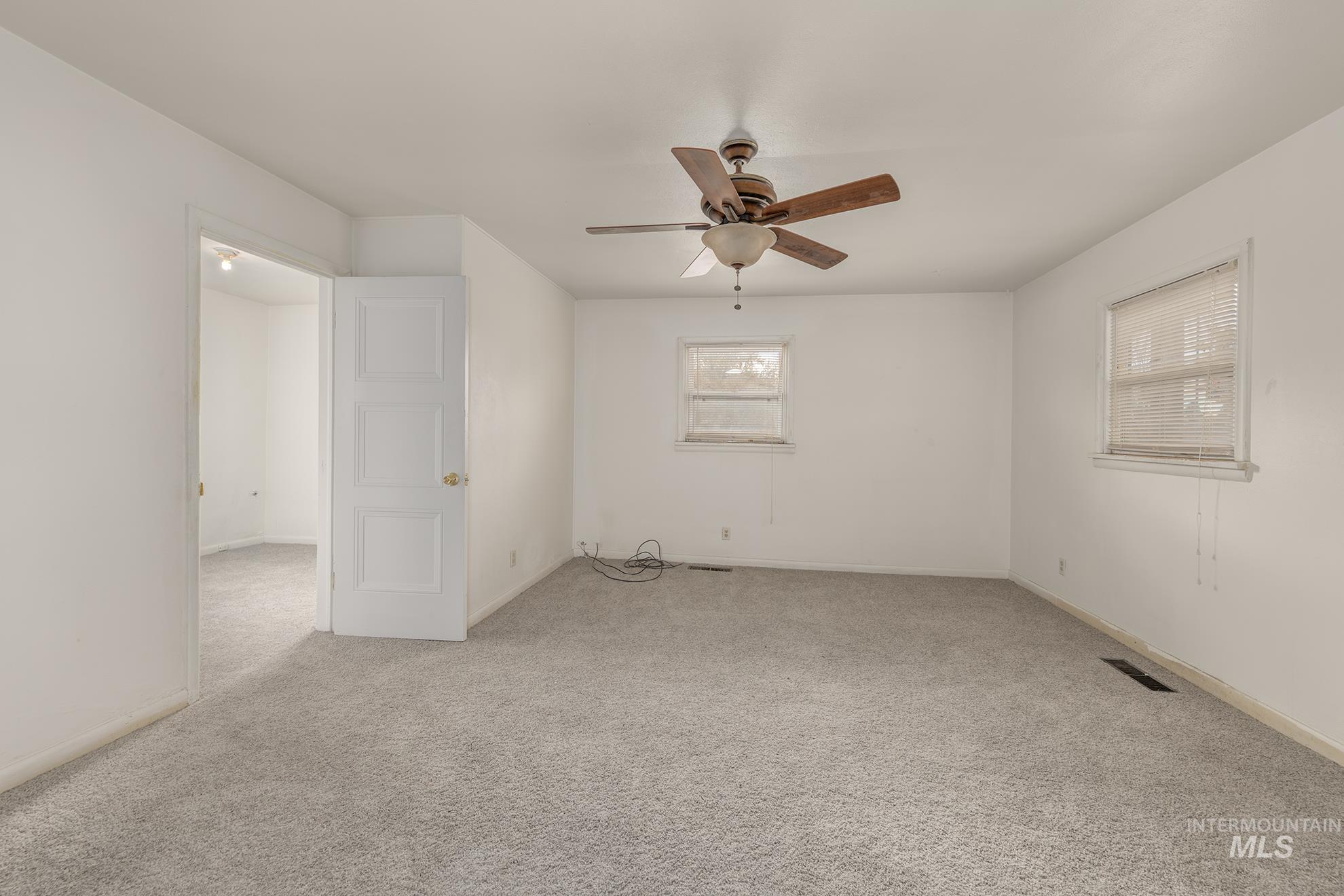 Unfurnished room with carpet floors and a ceiling fan