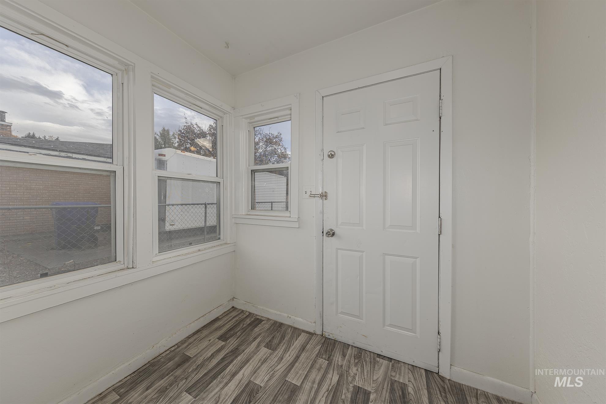 Doorway featuring wood finished floors and baseboards