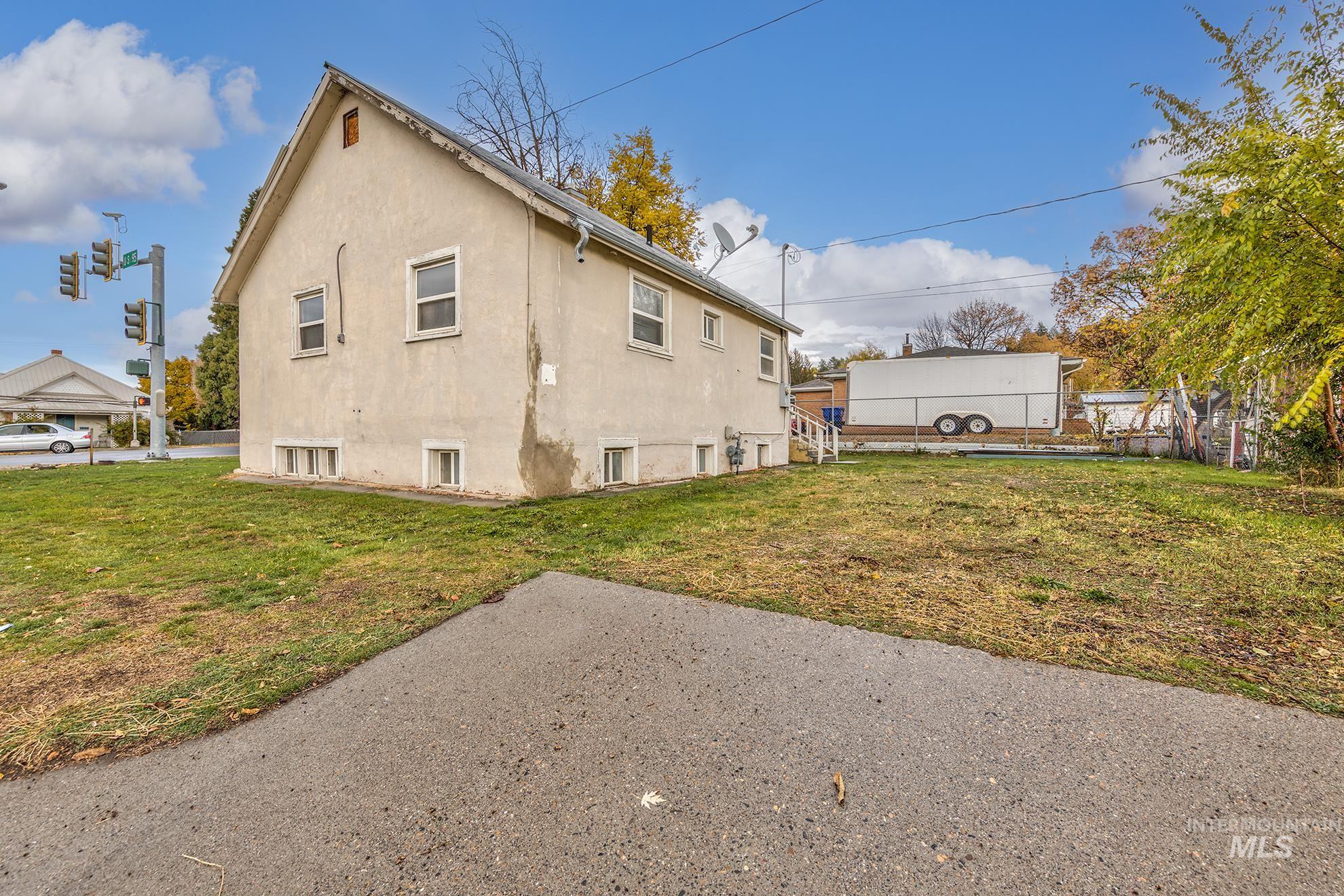 Rear view of house with stucco siding and a yard