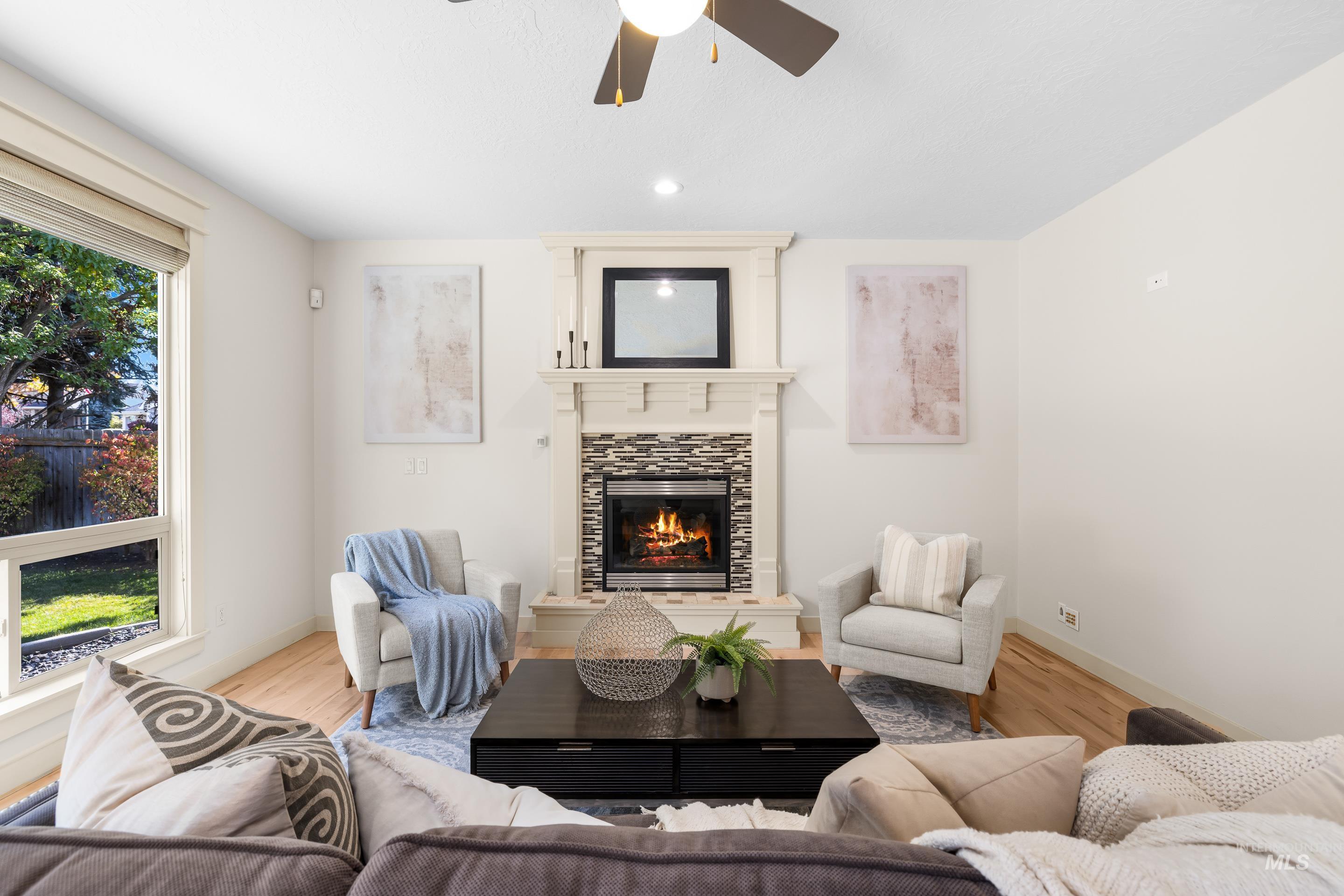 Living area featuring wood finished floors, a ceiling fan, a tile fireplace, and recessed lighting