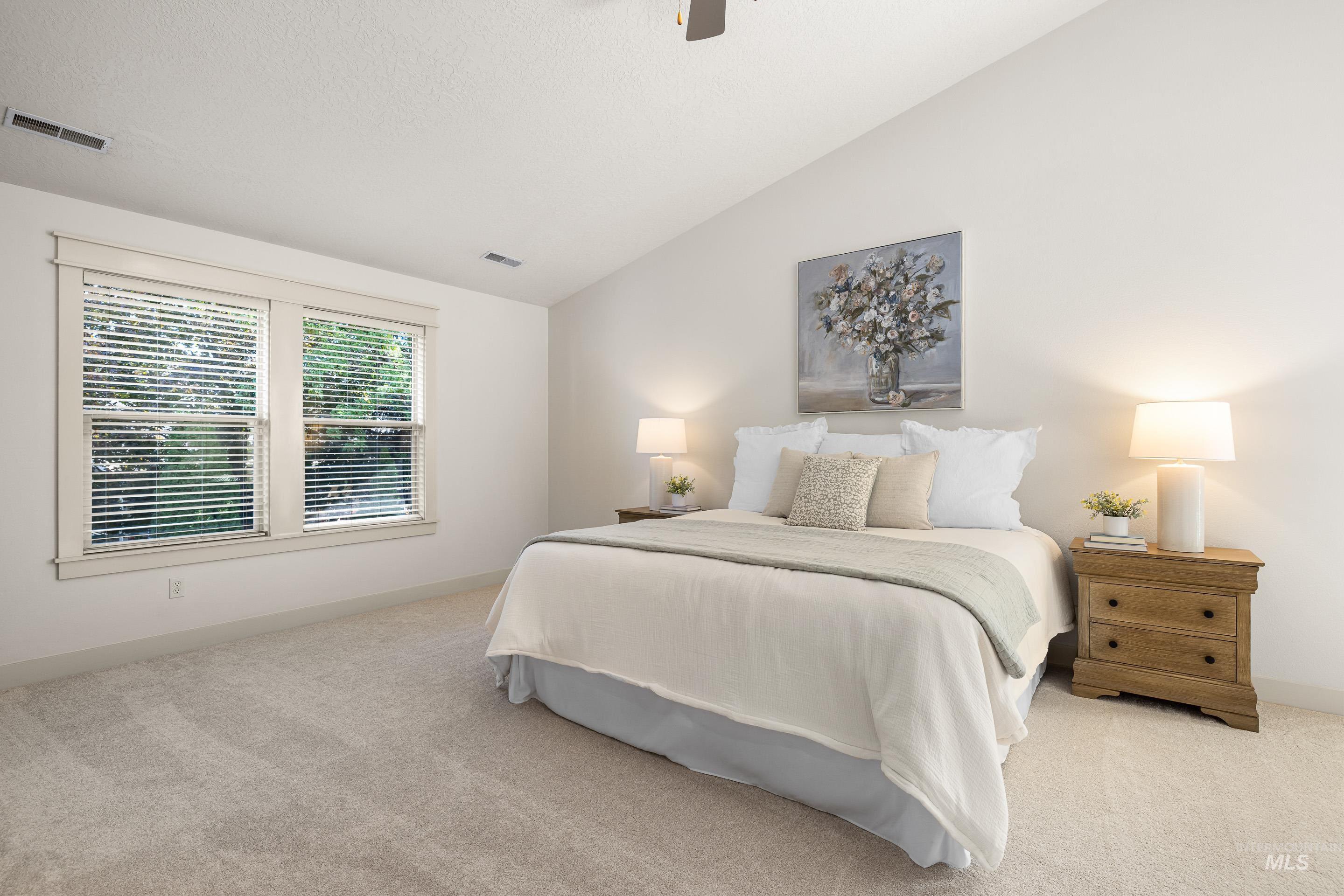 Bedroom featuring lofted ceiling, light carpet, and a ceiling fan
