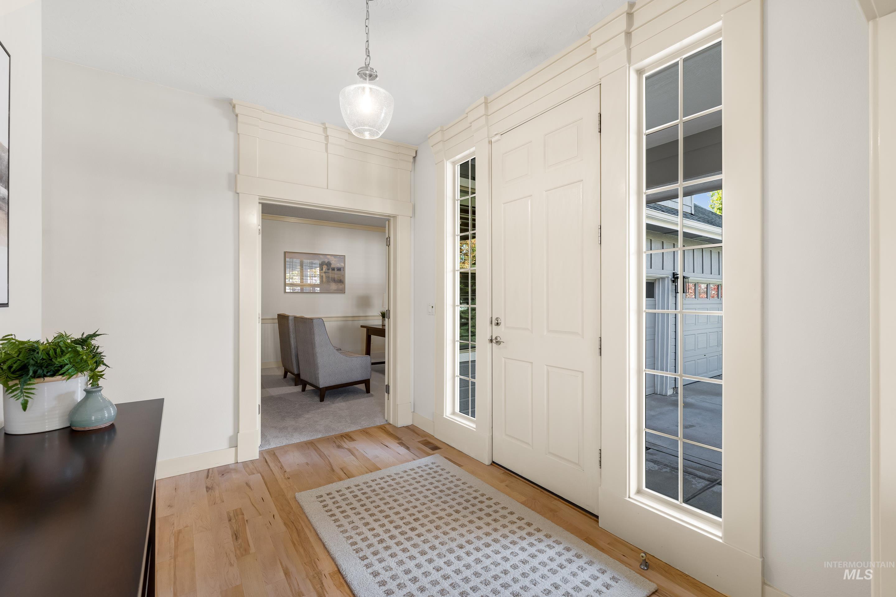 Entrance foyer with light wood-type flooring and baseboards