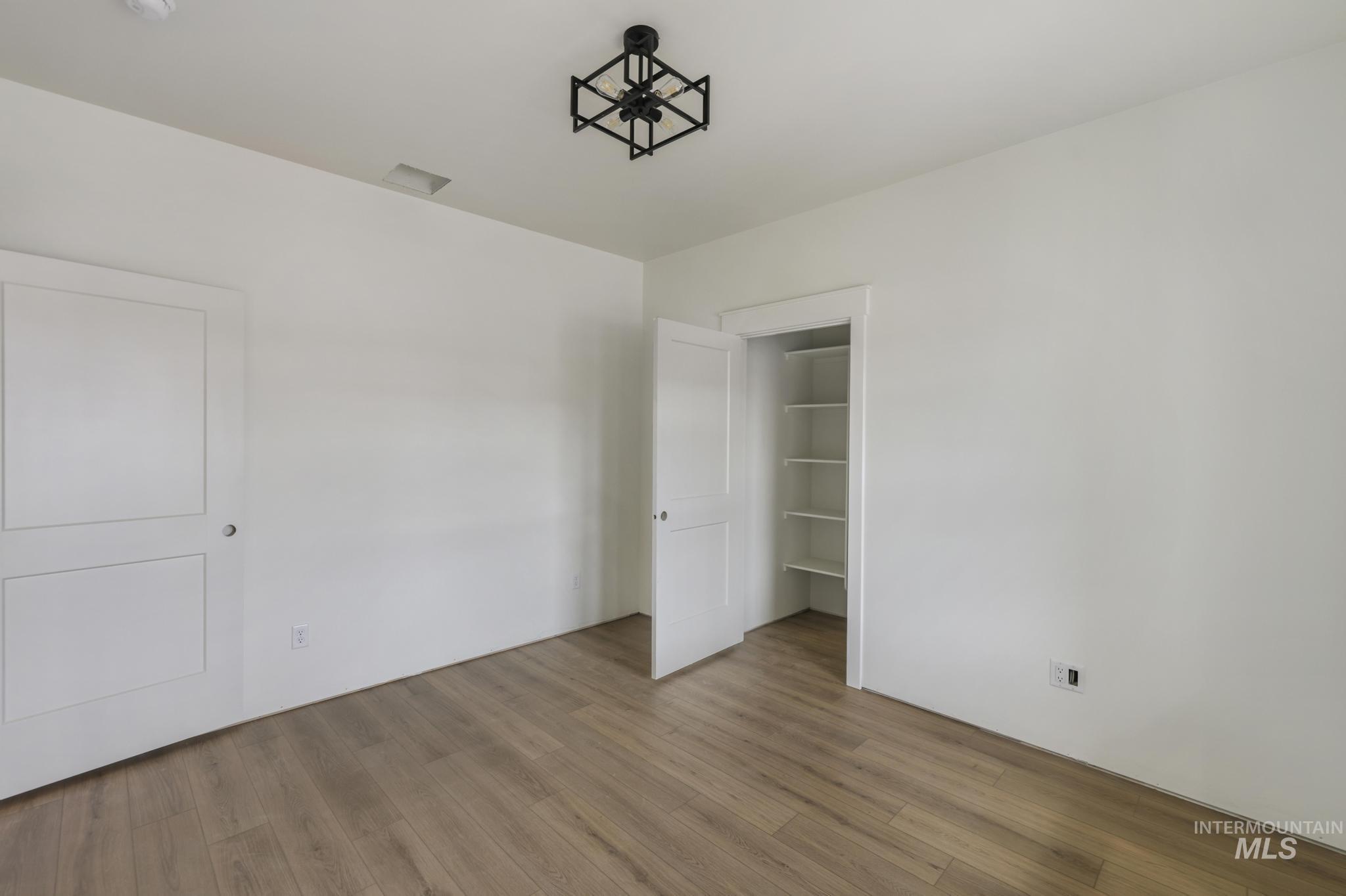 Unfurnished bedroom with wood finished floors