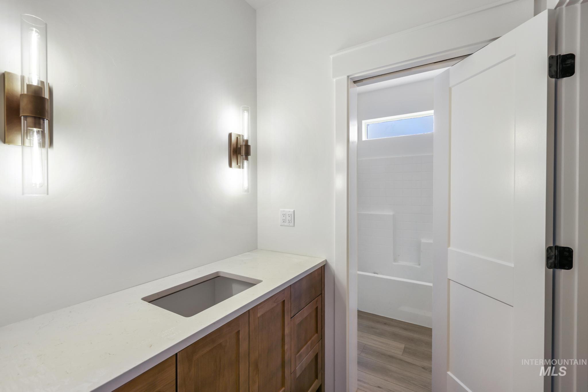 Full bathroom with vanity, light wood-style floors, and tub / shower combination