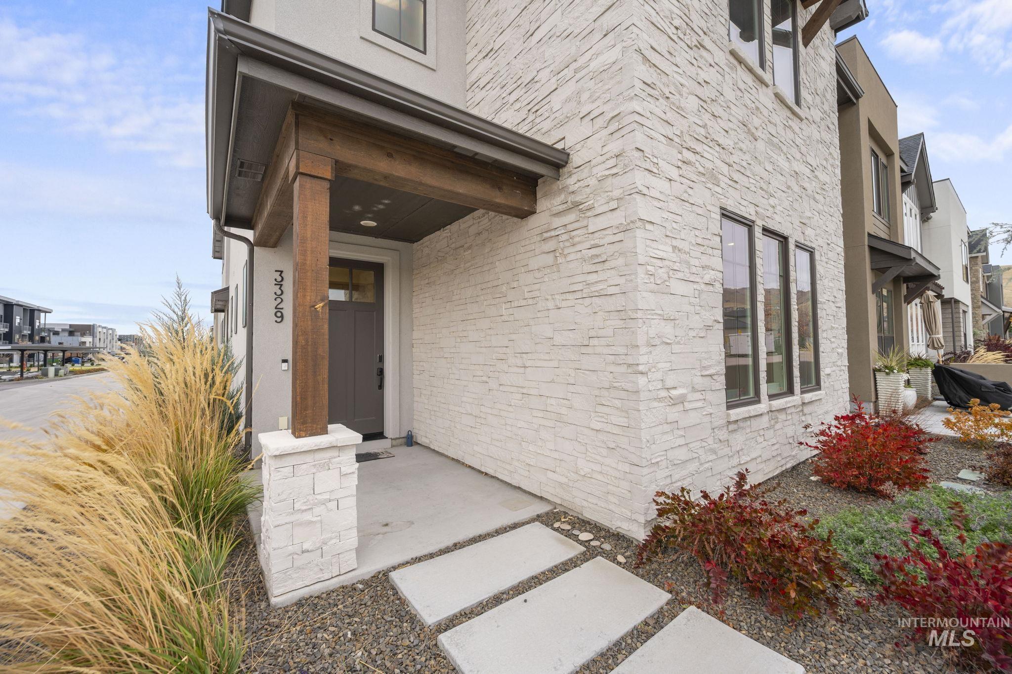 View of exterior entry featuring stone siding and stucco siding