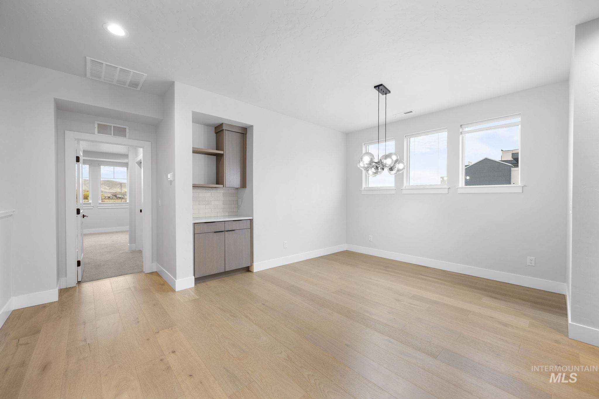 Unfurnished dining area with light wood-type flooring, a chandelier, and recessed lighting