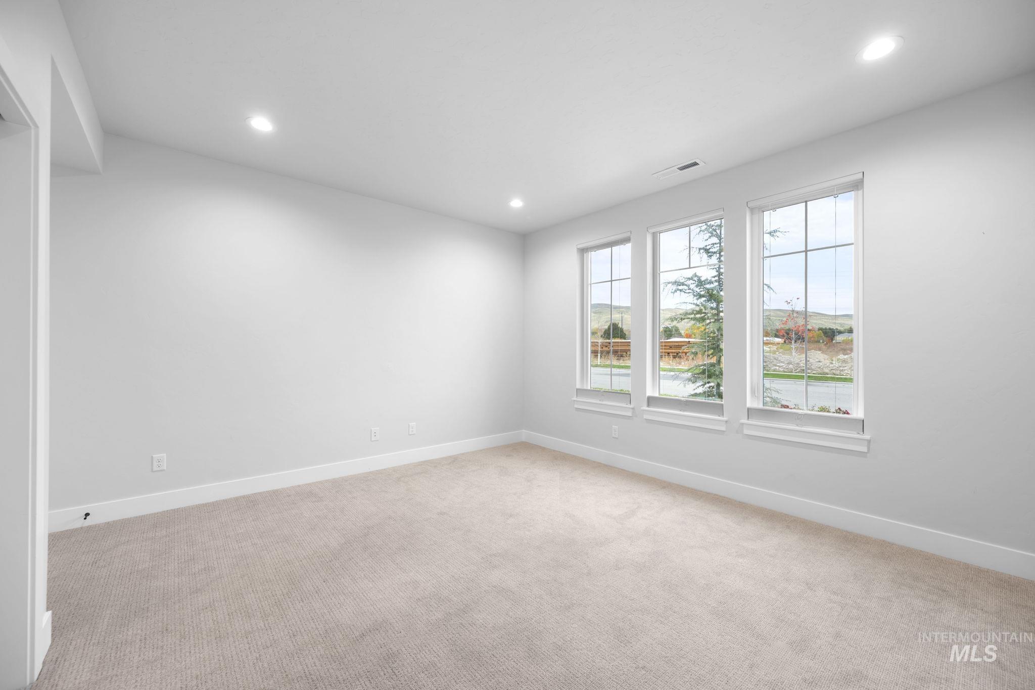 Spare room with recessed lighting and light carpet
