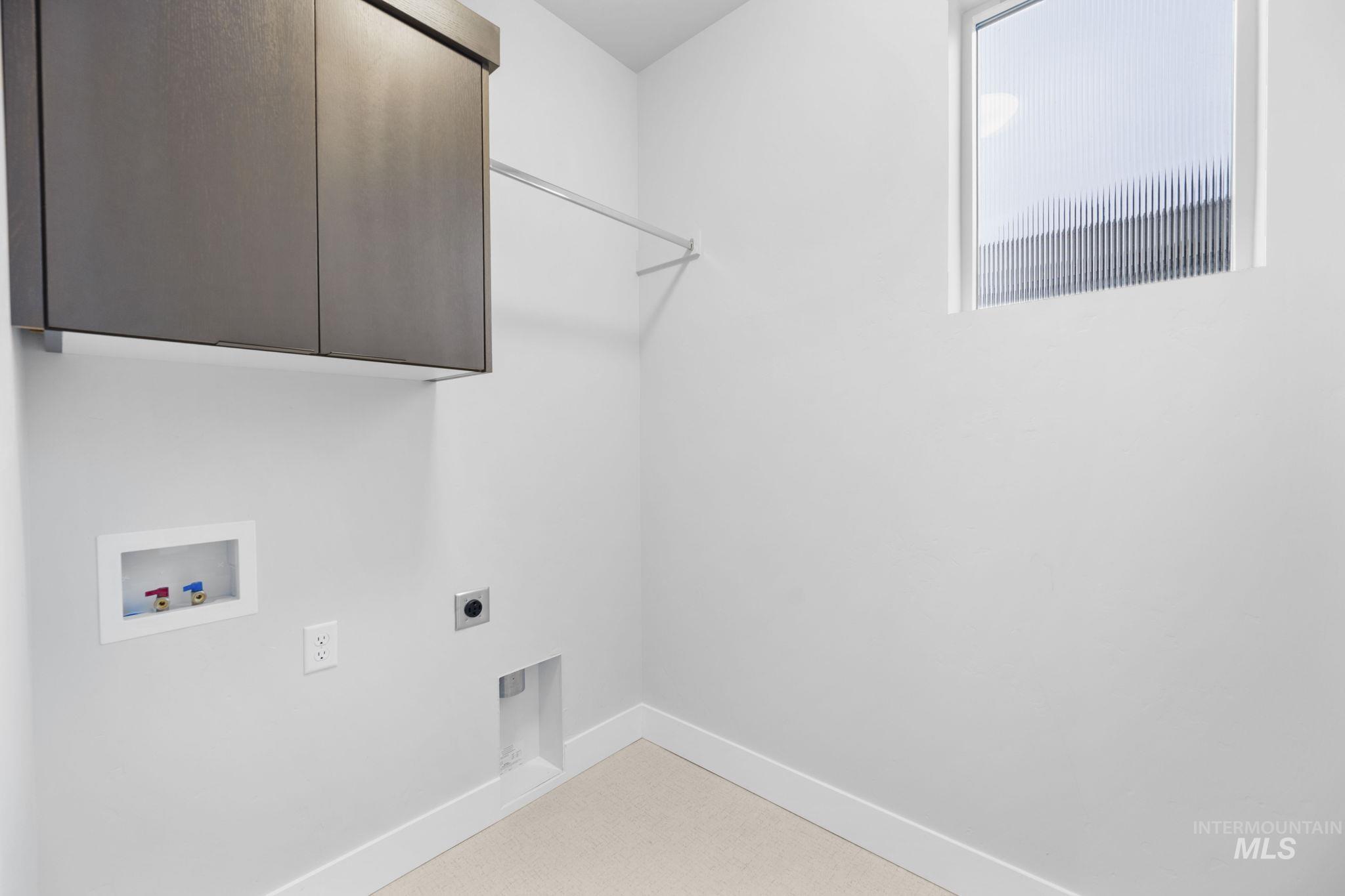 Laundry room with electric dryer hookup, cabinet space, and hookup for a washing machine