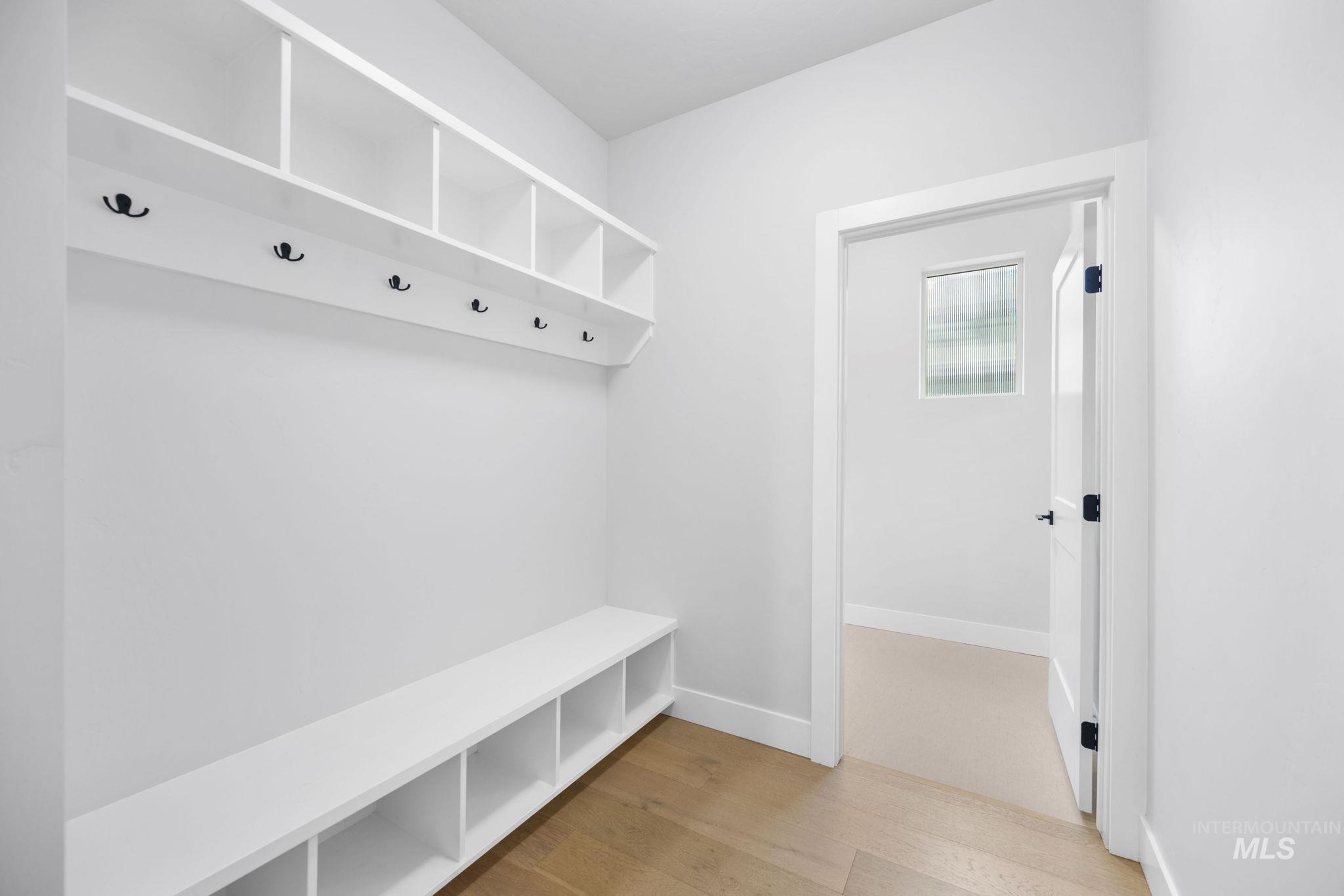 Mudroom with light wood-style flooring and baseboards
