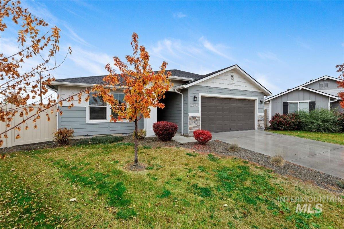 Ranch-style home with concrete driveway, a front lawn, and a garage