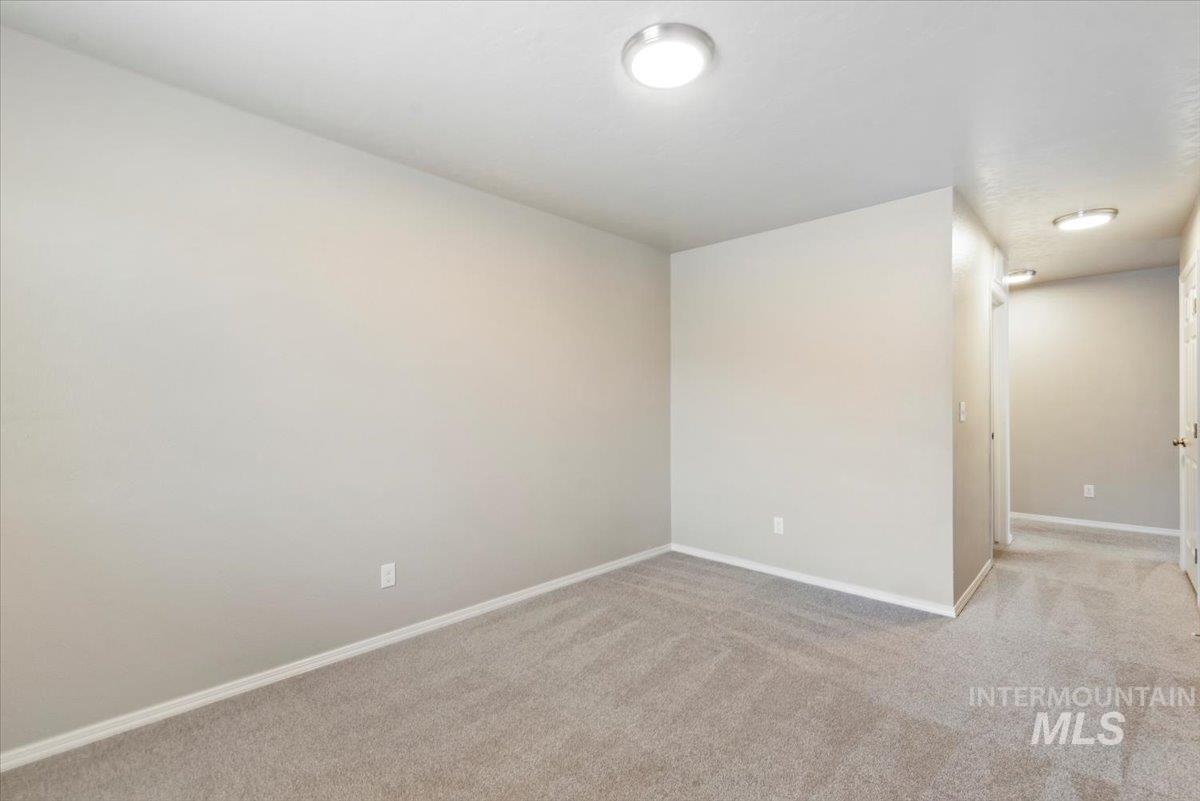 Unfurnished room with light colored carpet and baseboards