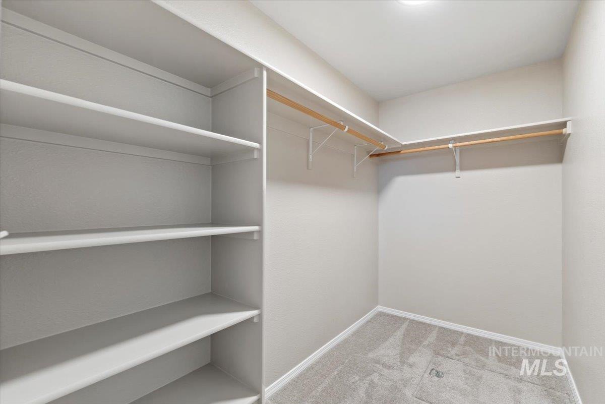 Spacious closet with light carpet