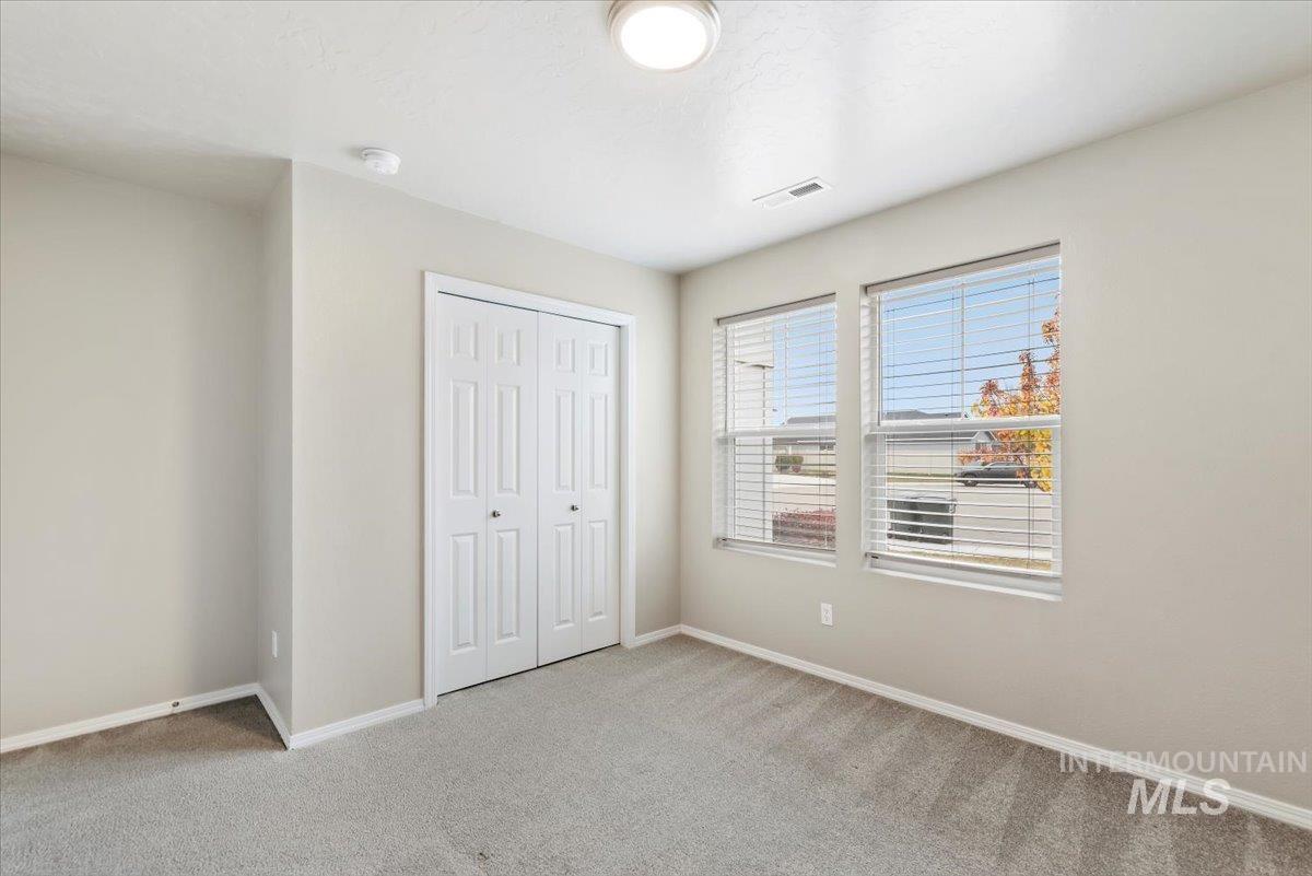 Unfurnished bedroom featuring light carpet and a closet
