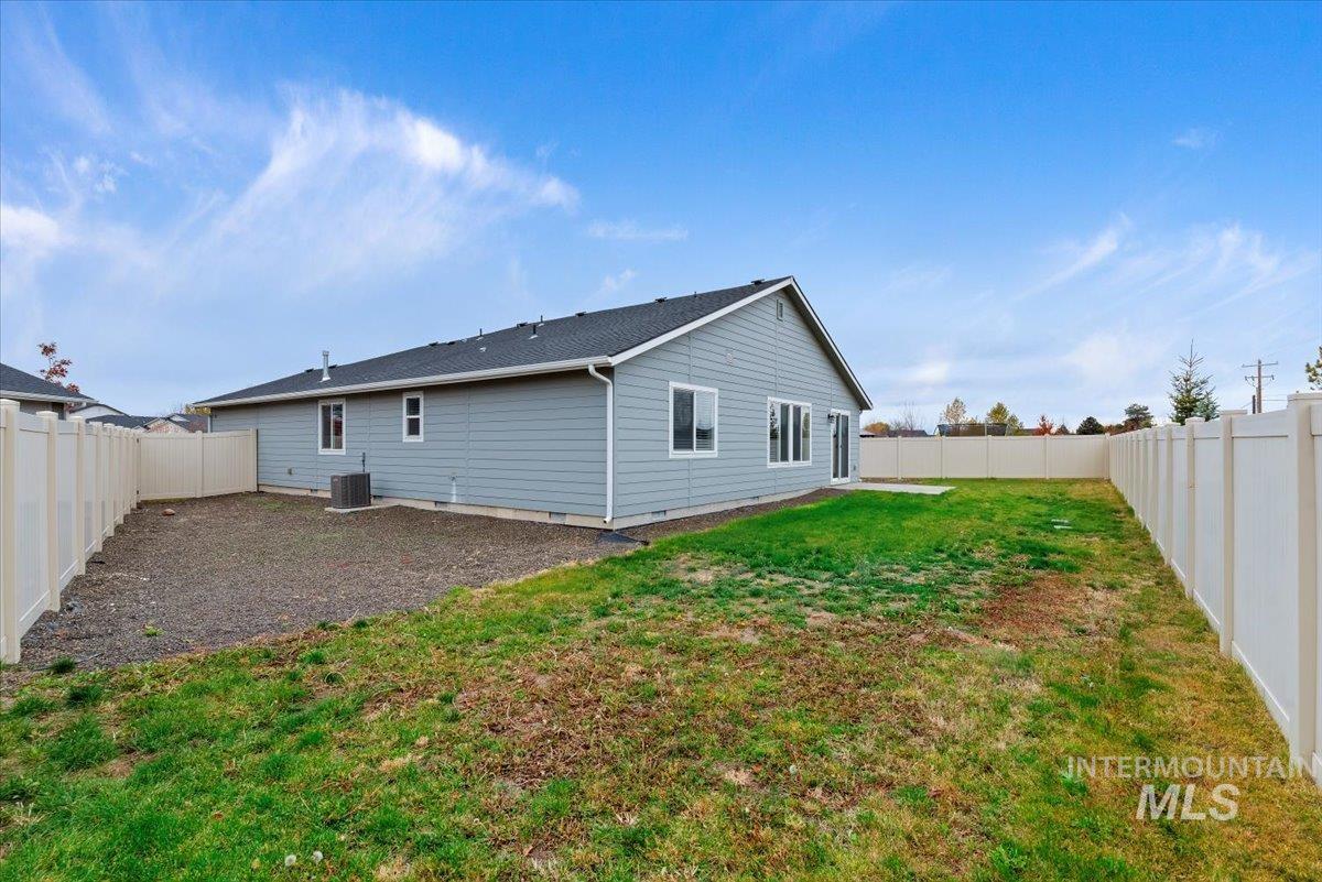 Rear view of house featuring a fenced backyard