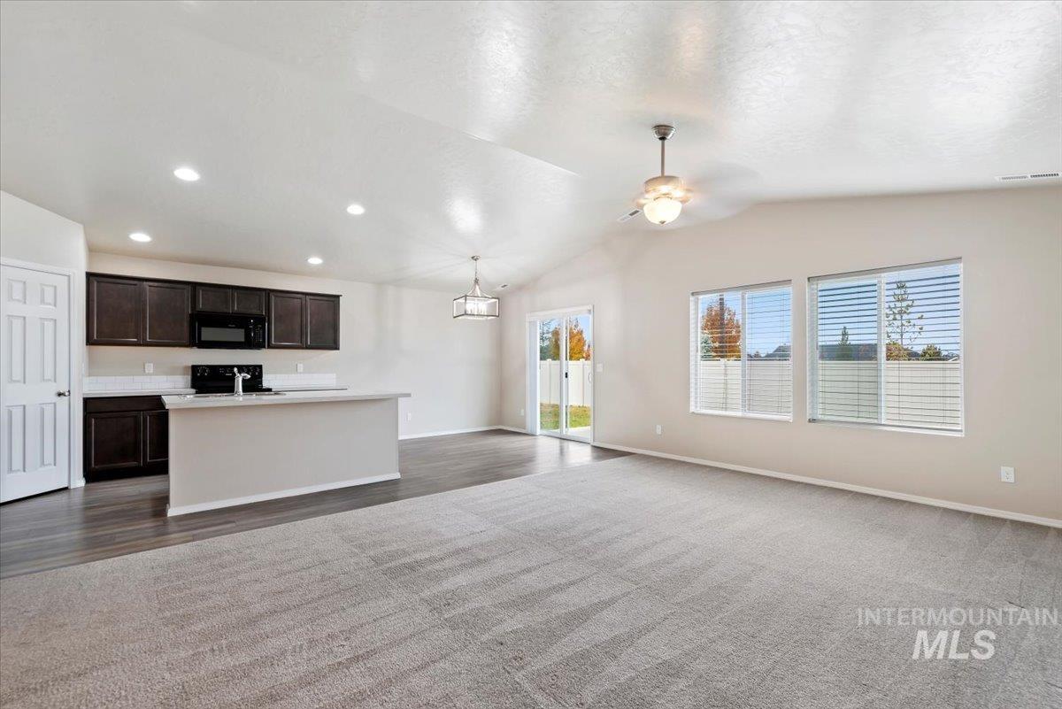 Unfurnished living room with lofted ceiling, ceiling fan, recessed lighting, and dark wood-type flooring