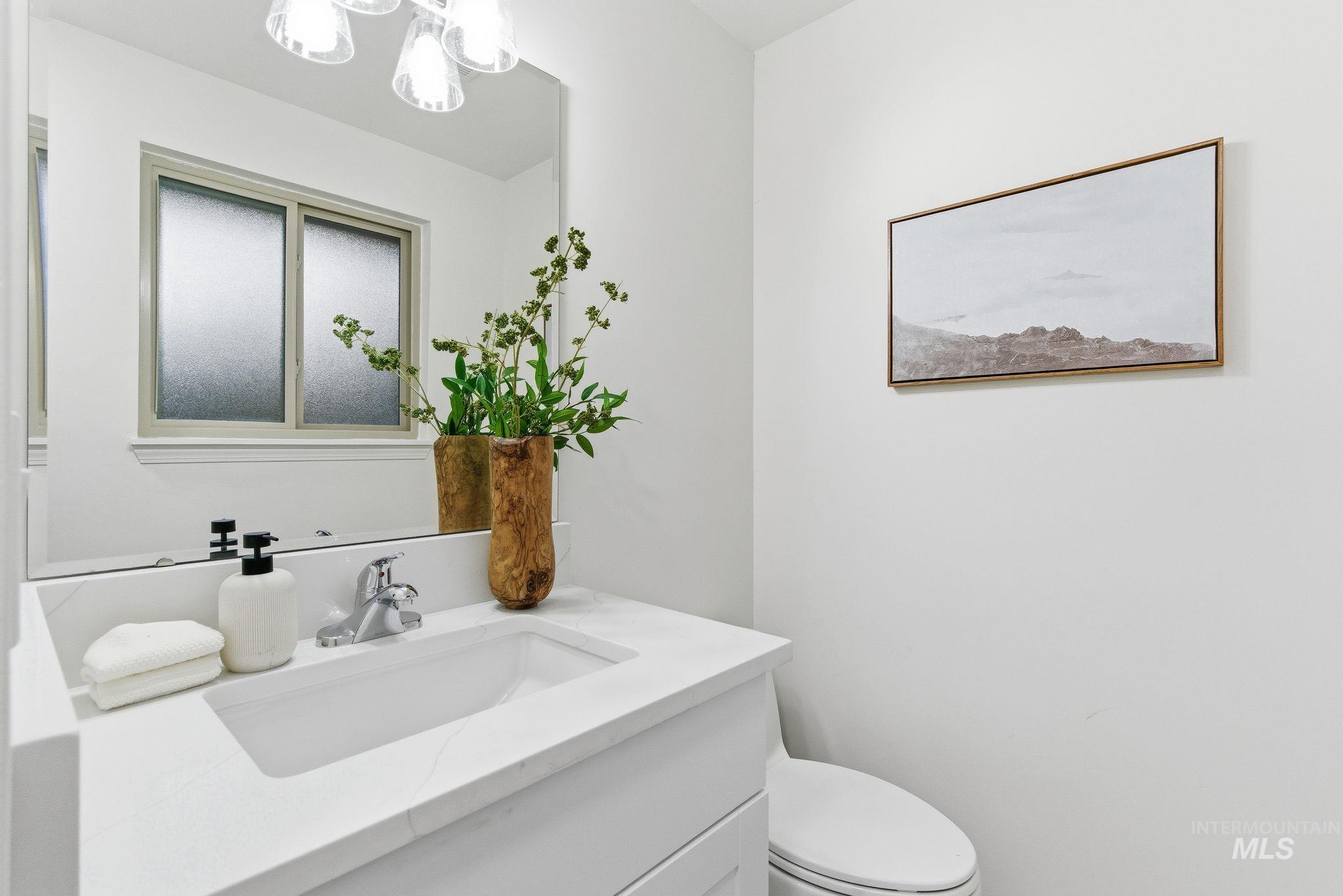 Half bathroom featuring vanity and a chandelier