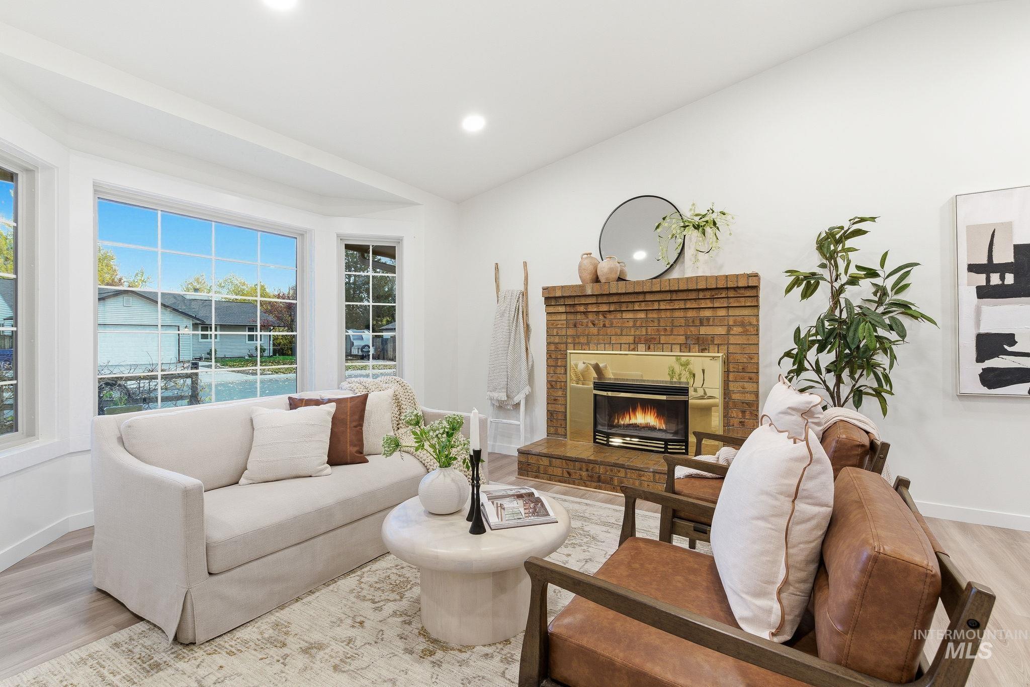 Living area with light wood finished floors, a fireplace, and recessed lighting