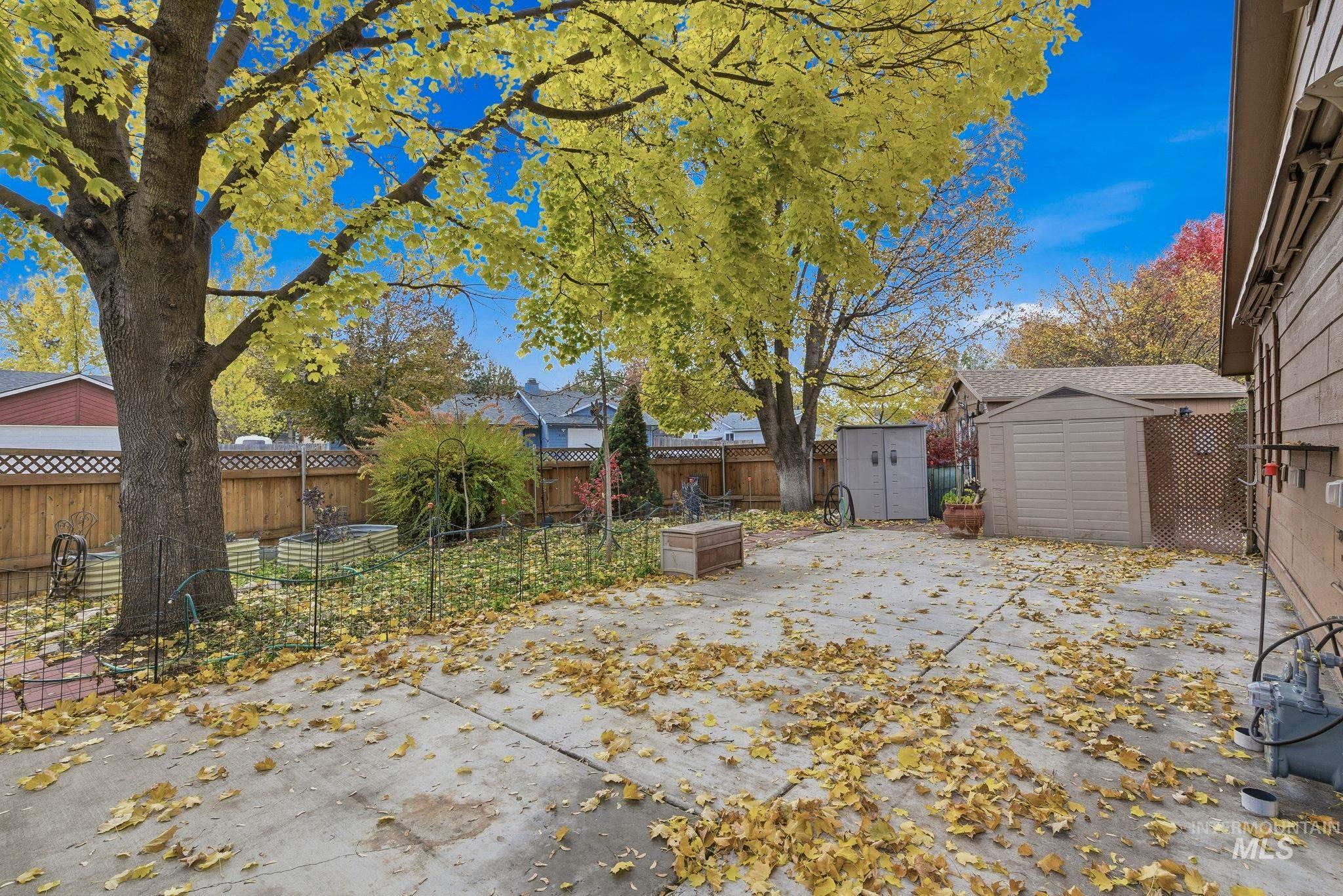 Fenced backyard featuring a storage shed and a patio