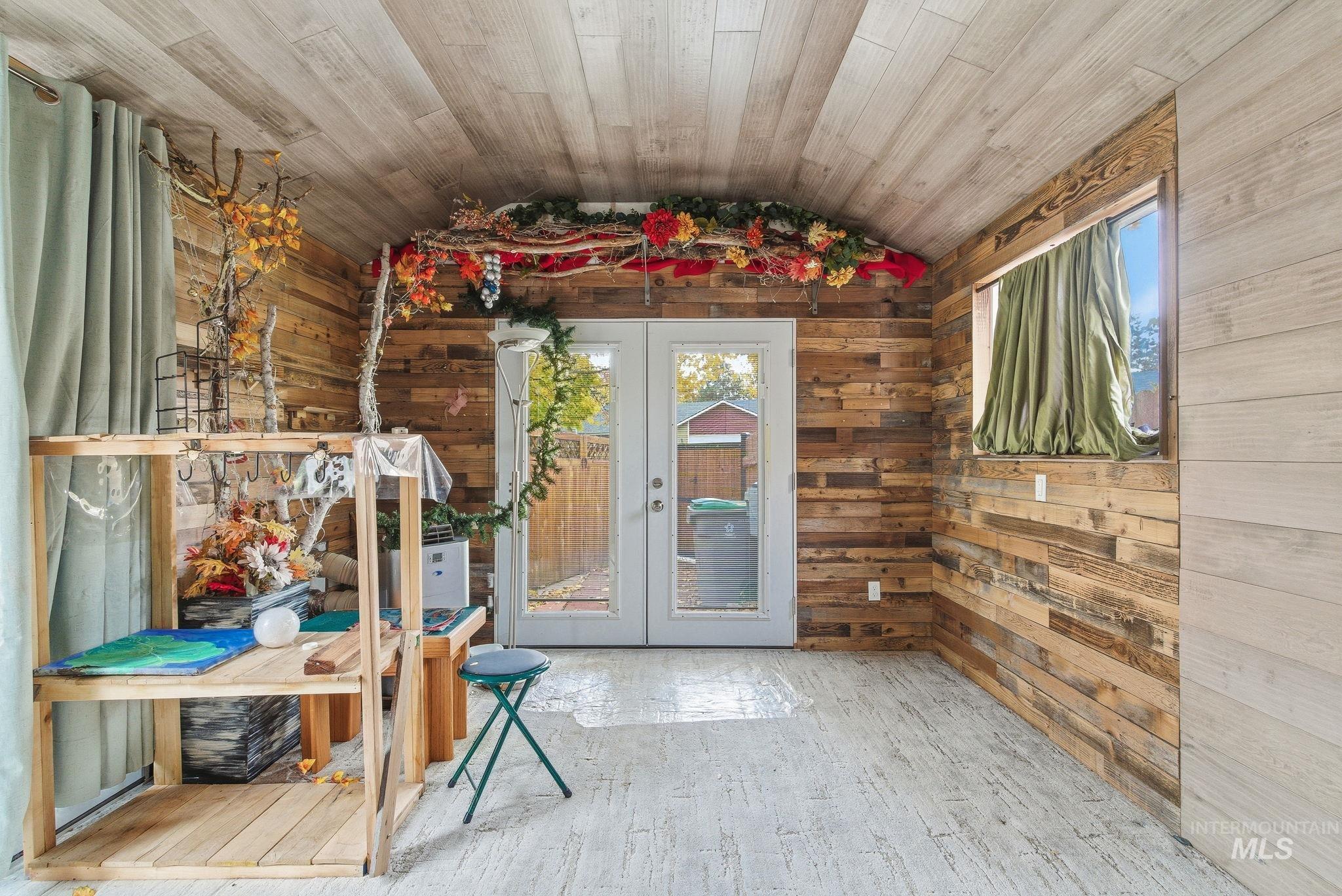 Entryway featuring french doors, wood walls, wood finished floors, wood ceiling, and lofted ceiling