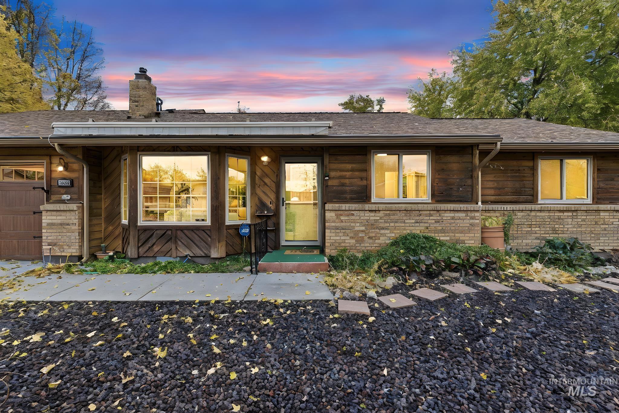 Ranch-style house with a chimney, a garage, and brick siding
