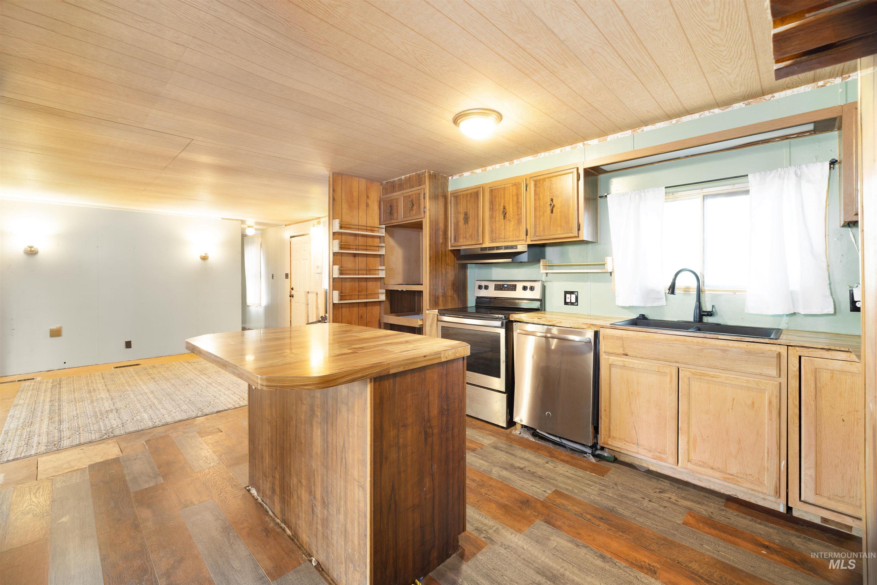 Kitchen with open shelves, stainless steel appliances, butcher block countertops, dark wood finished floors, and wooden ceiling
