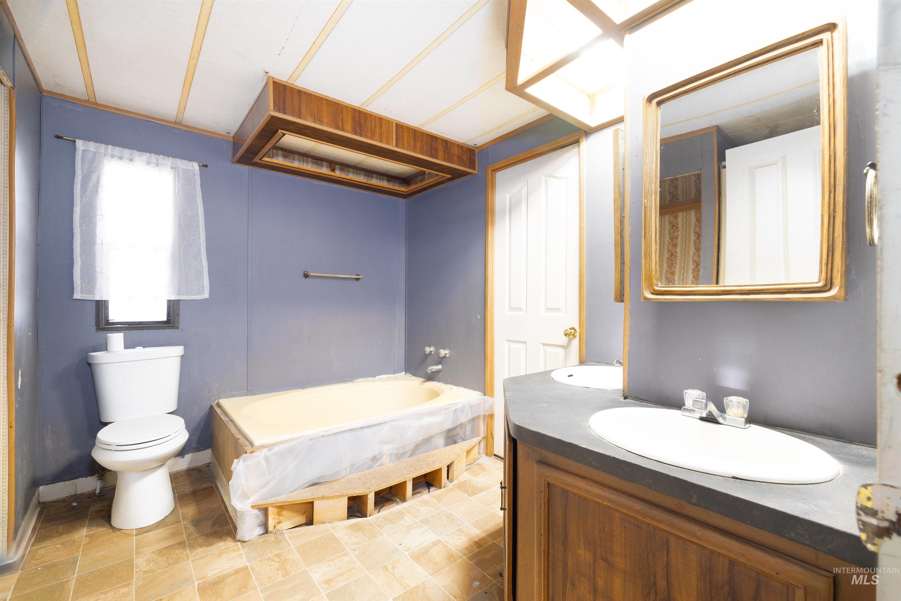 Full bathroom featuring a garden tub and vanity