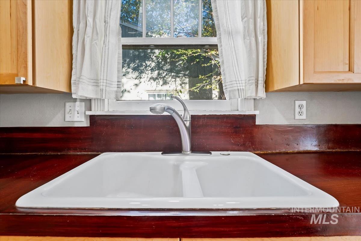 Kitchen view of dark countertops and light brown cabinetry
