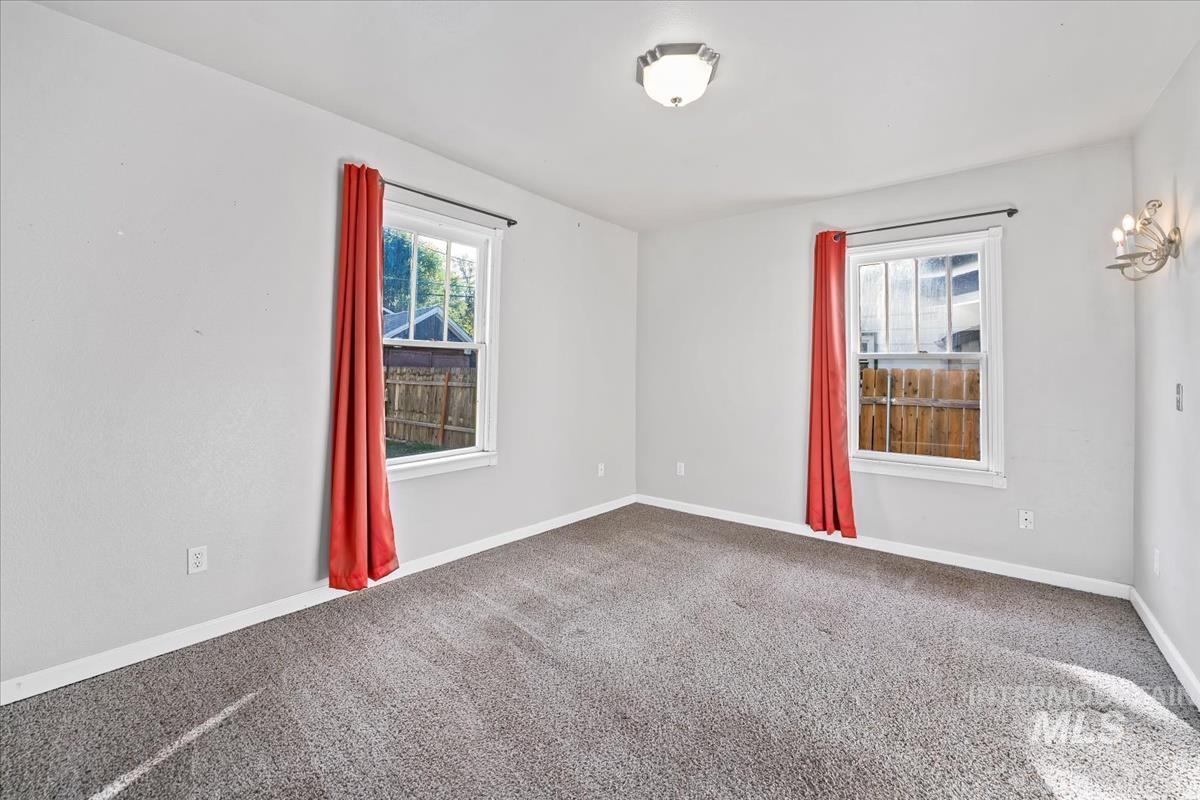 Spare room featuring carpet floors and baseboards