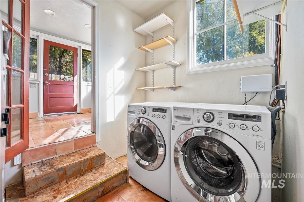 Laundry area with plenty of natural light, washer and dryer, and tile patterned flooring