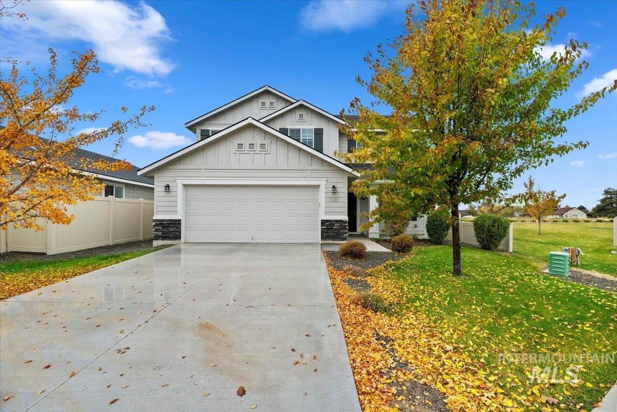 Traditional-style house featuring stone siding, concrete driveway, board and batten siding, and a garage