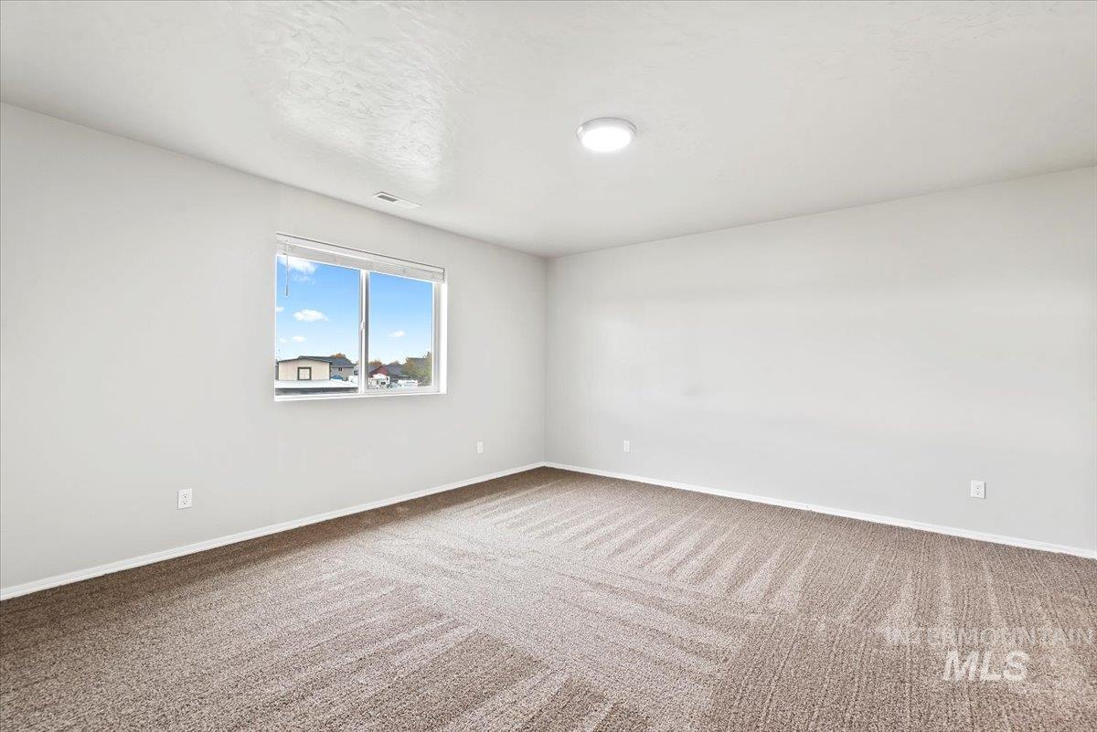 Unfurnished room with carpet floors and a textured ceiling