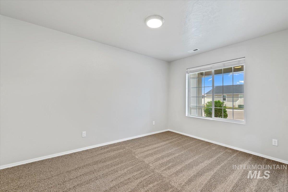 Empty room with carpet flooring and baseboards