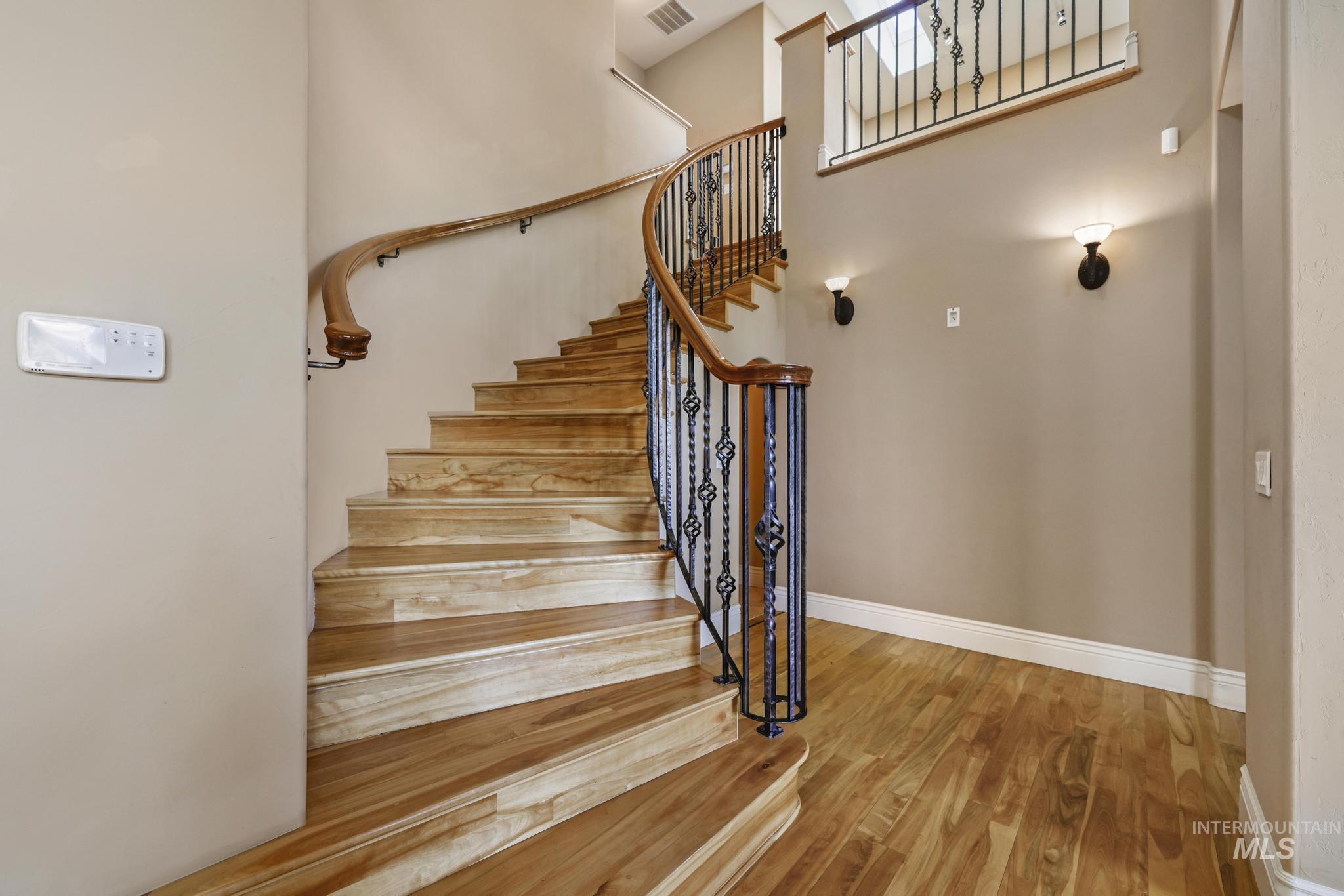 Staircase featuring wood finished floors and baseboards