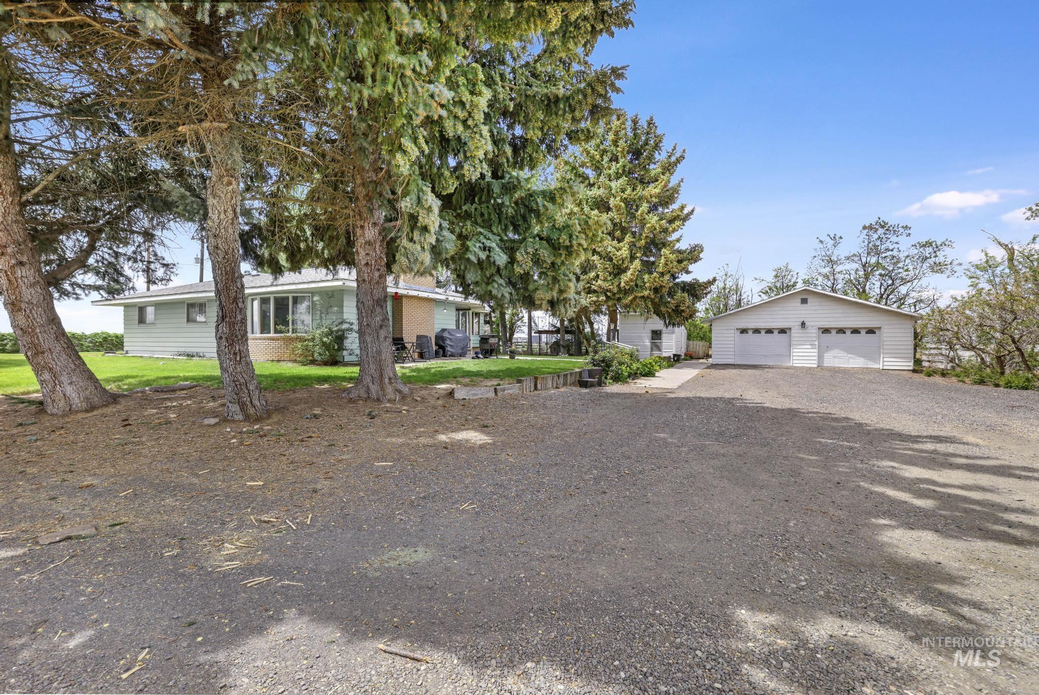 Single story home featuring a garage and an outbuilding
