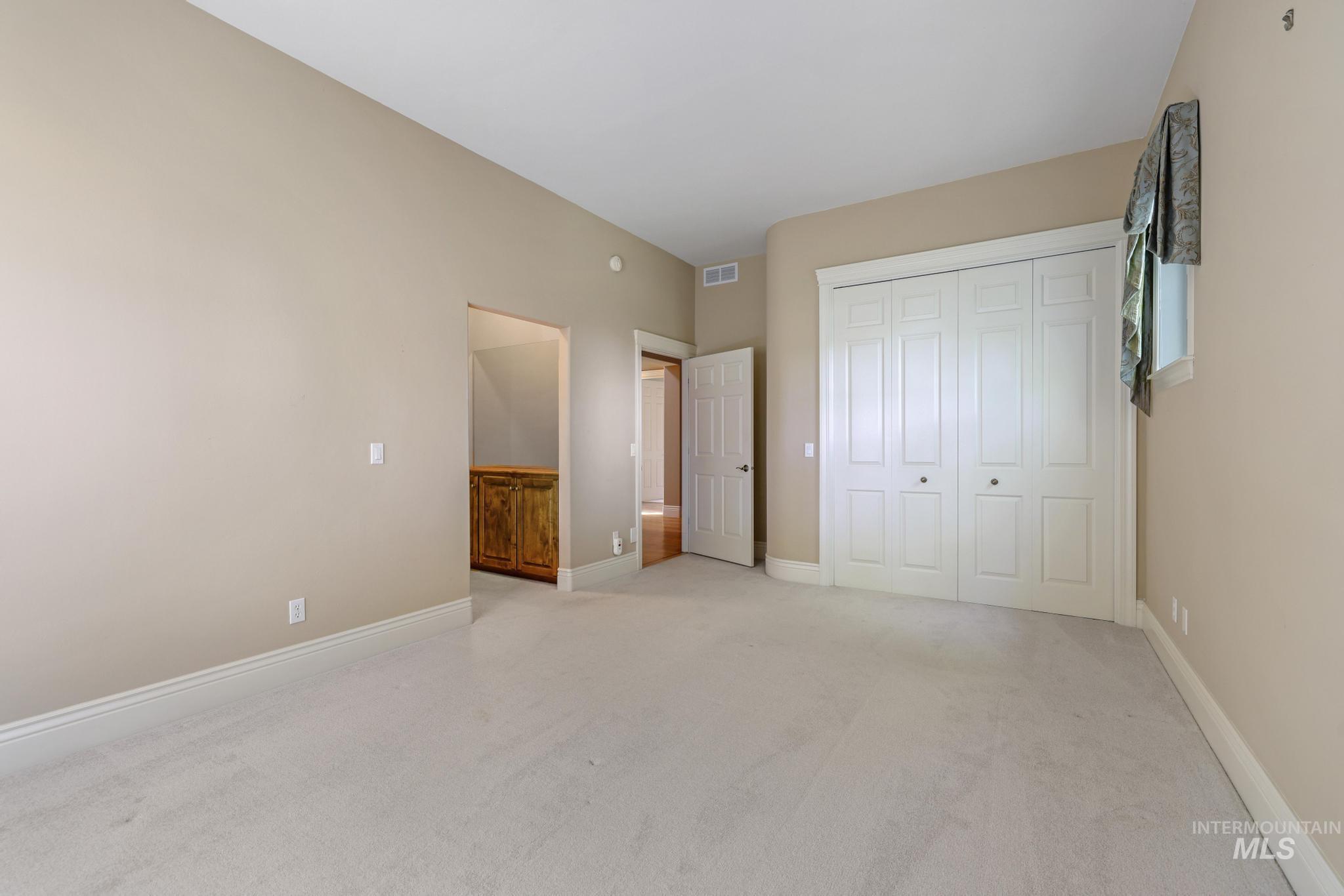 Unfurnished bedroom featuring light colored carpet and a closet
