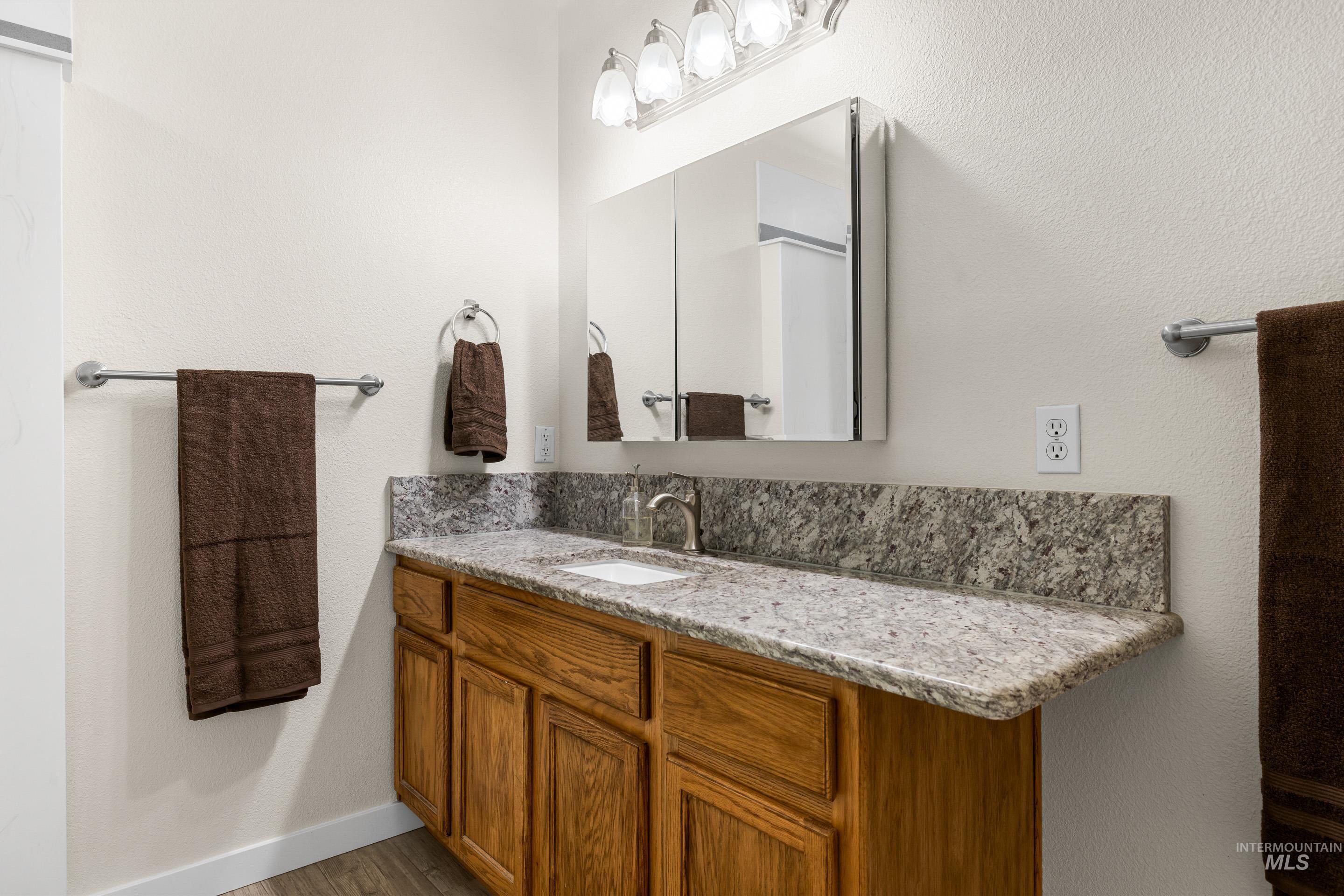 Bathroom with vanity and a textured wall