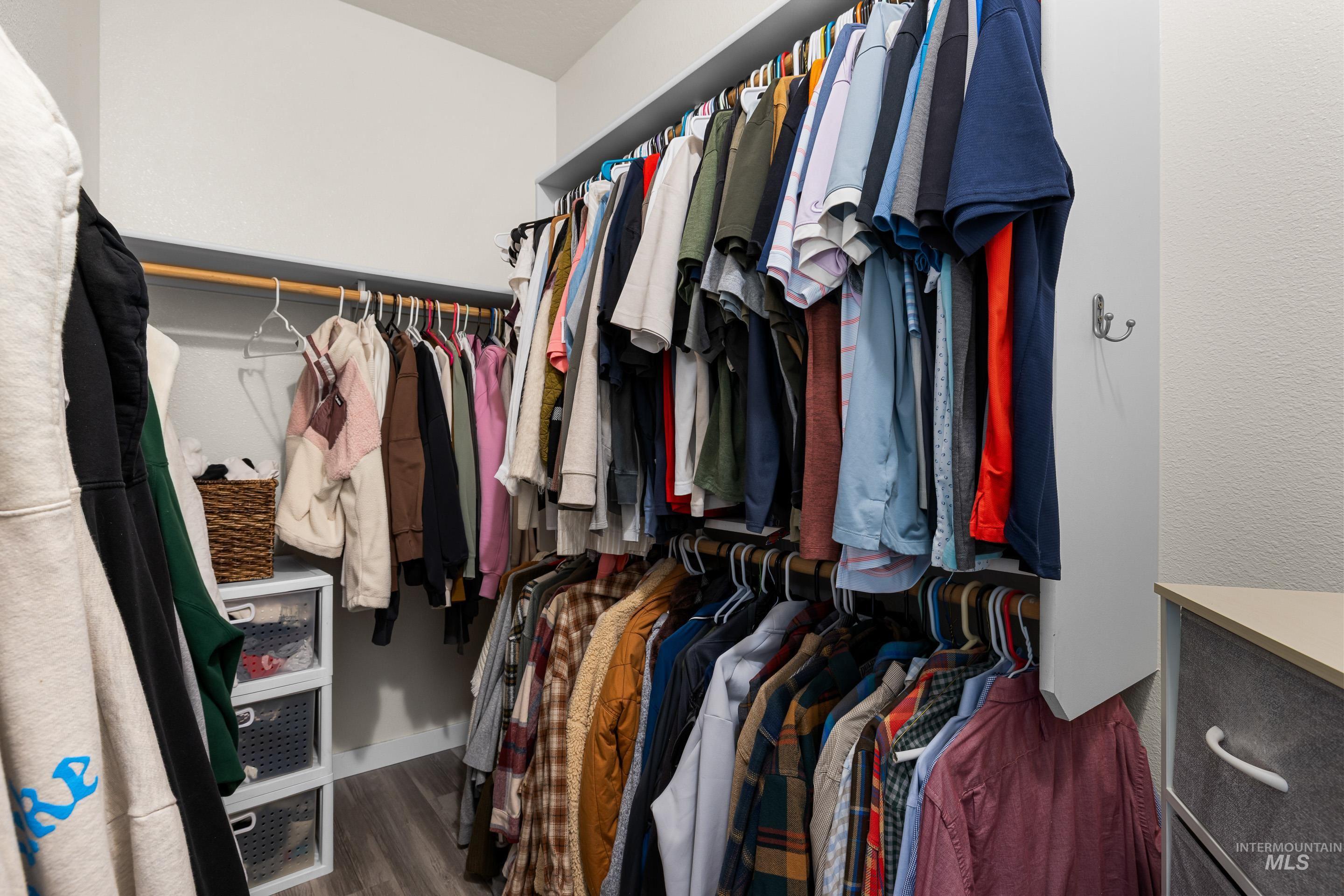 Spacious closet with dark wood-style flooring