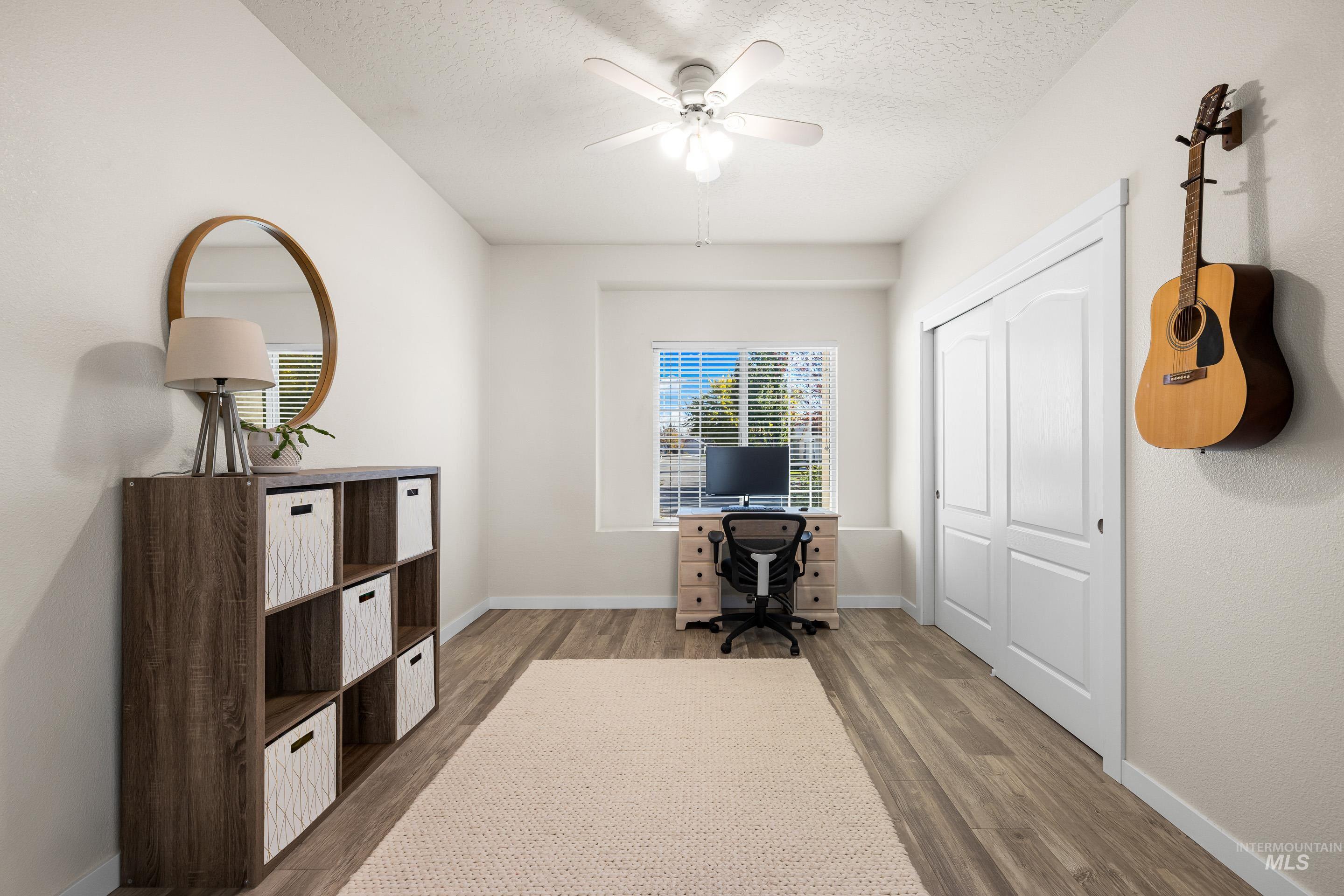 Office with wood finished floors, a textured ceiling, and a ceiling fan