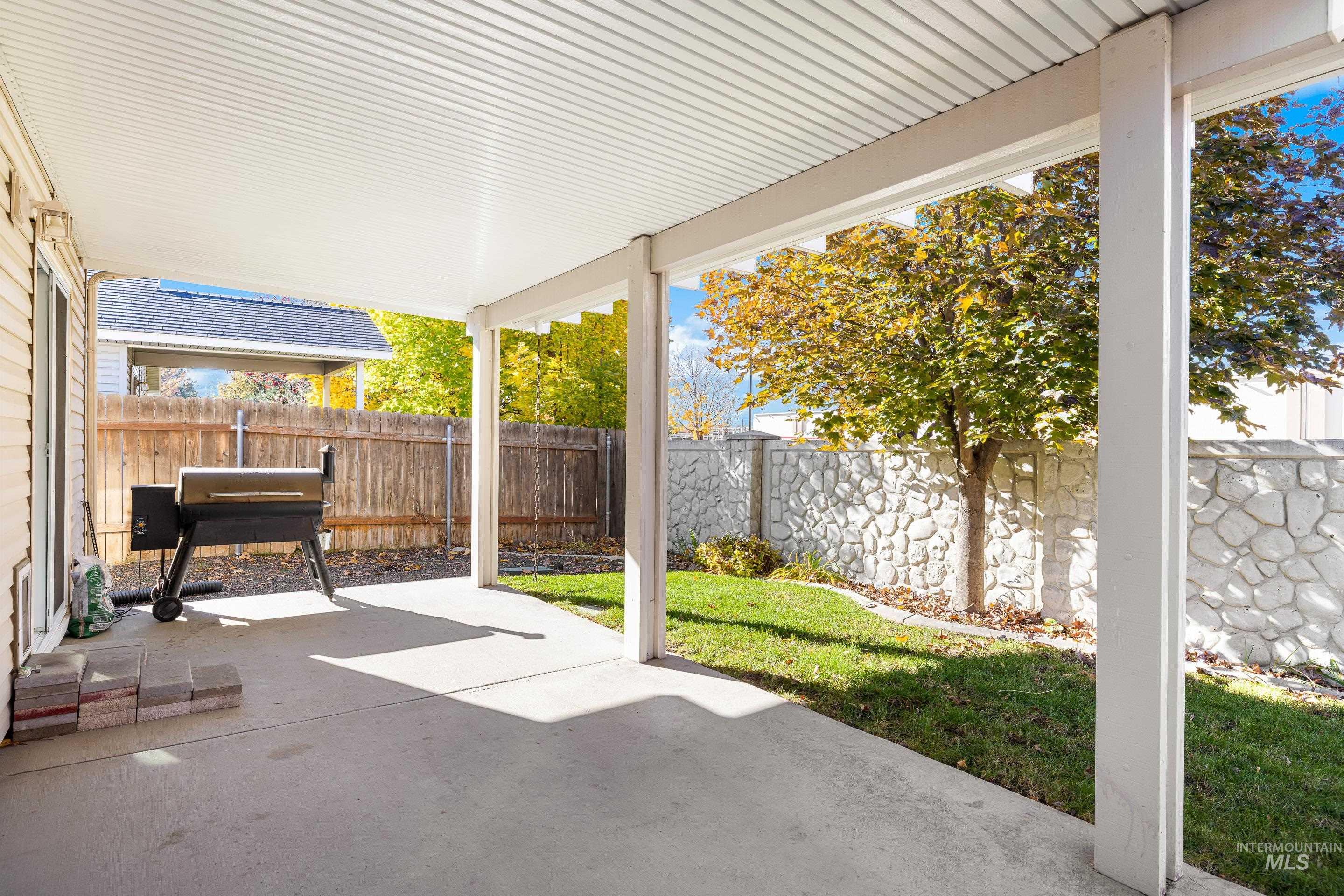 Fenced backyard with a patio and area for grilling