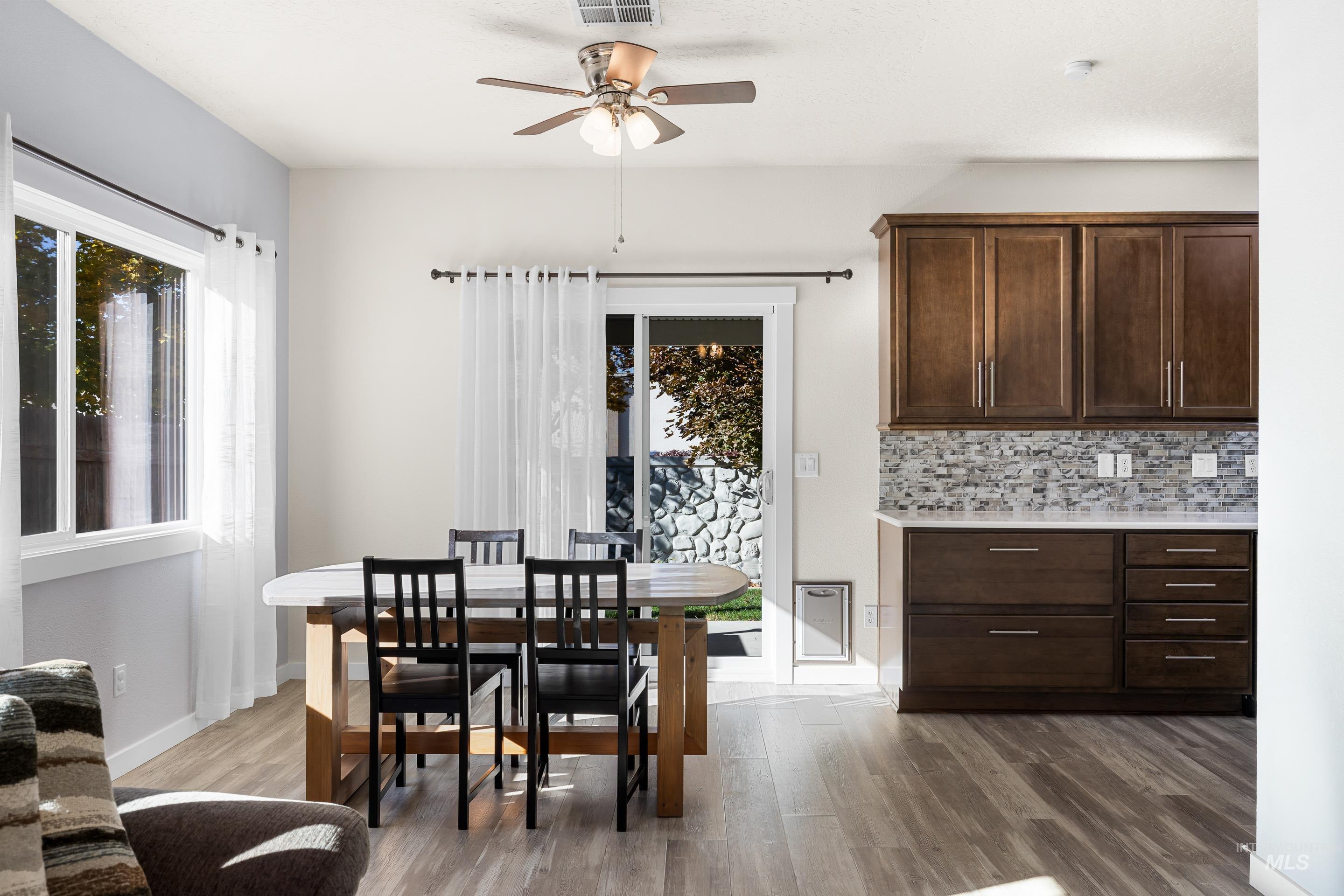 Dining area featuring dark wood-style floors and a ceiling fan