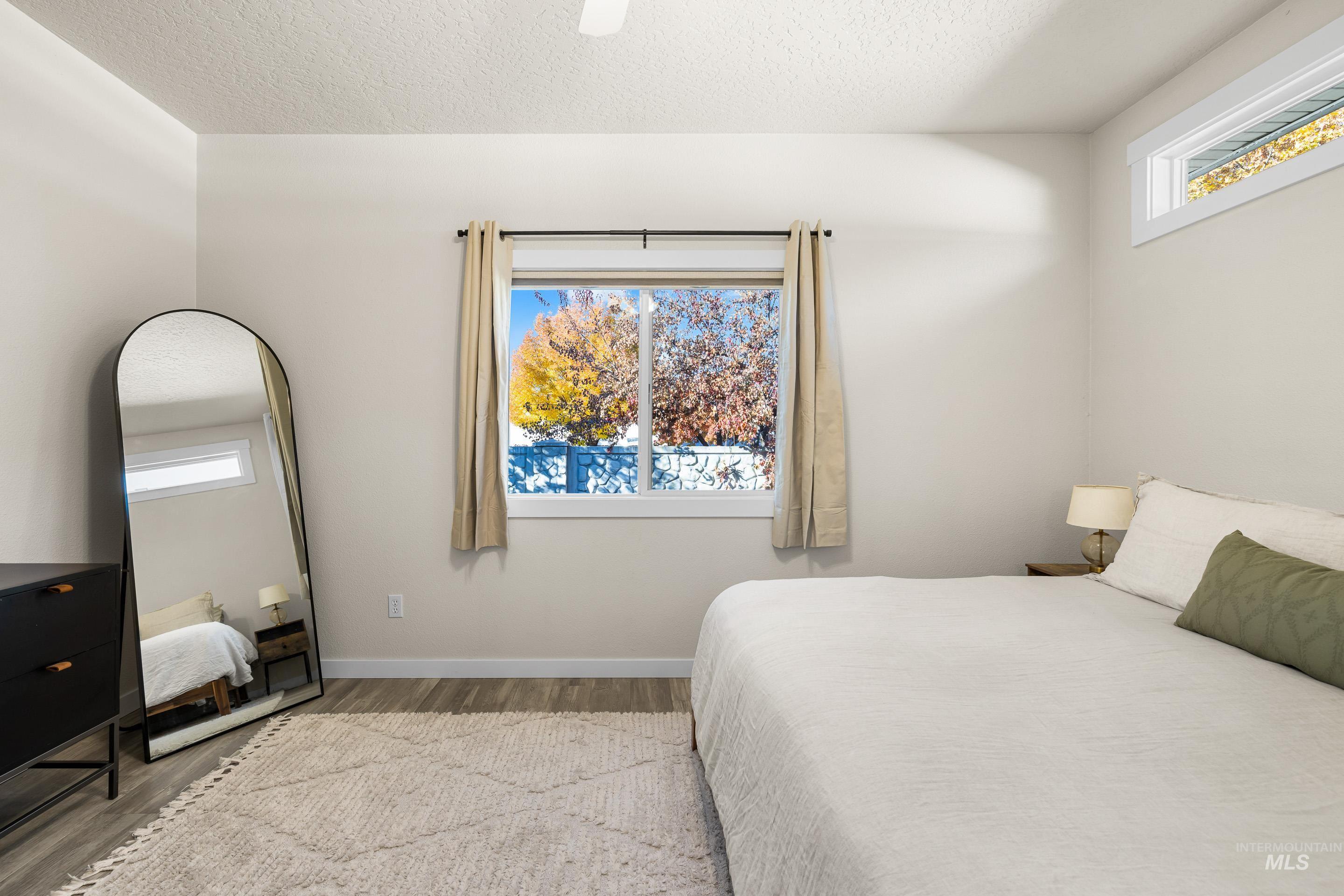 Bedroom featuring a textured ceiling, wood finished floors, and ceiling fan