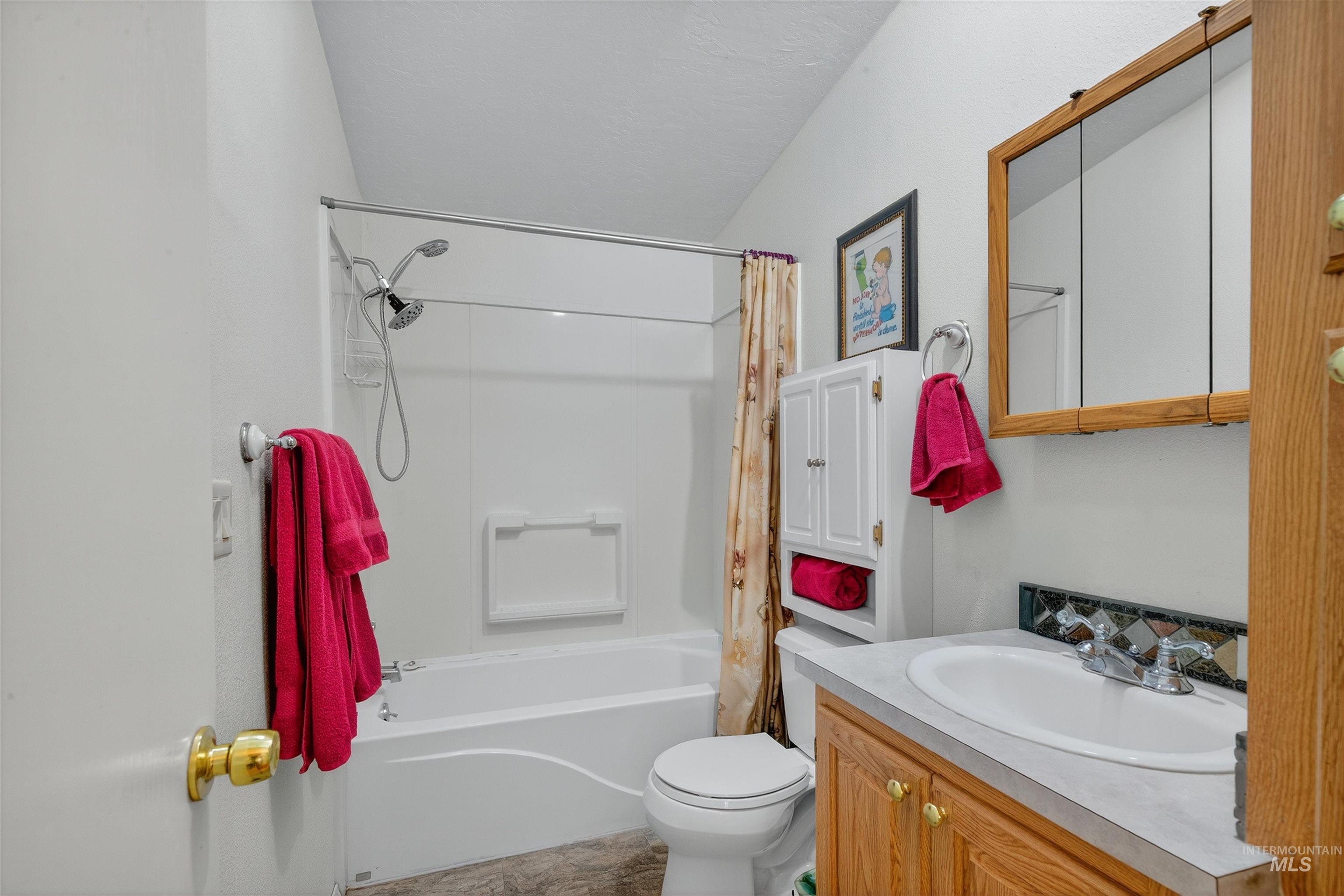 Bathroom featuring vanity and shower / bath combo with shower curtain